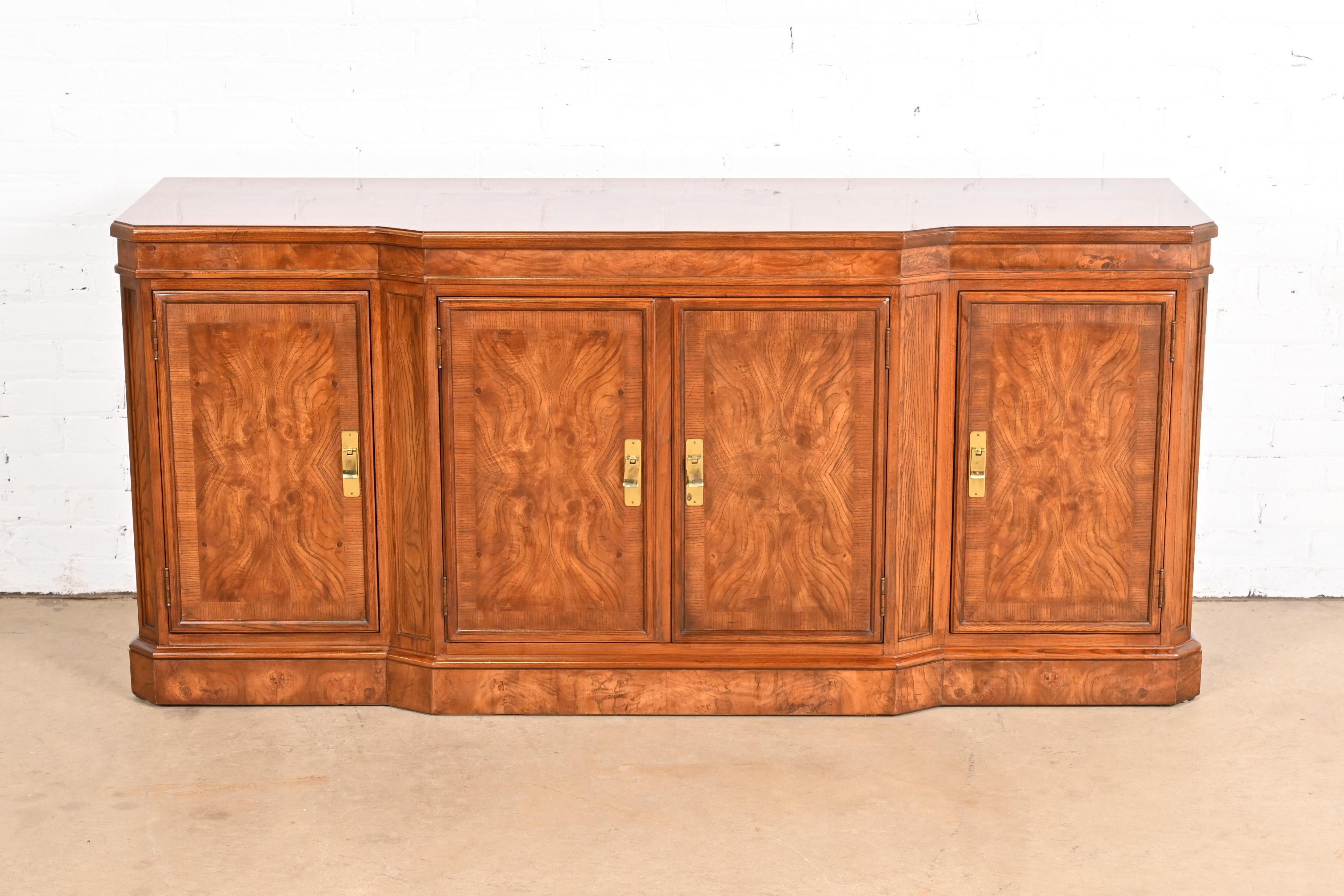 A gorgeous Modern Hollywood Regency style sideboard, credenza, or bar cabinet.

By Drexel Heritage

USA, Circa 1980s

Beautiful oak and book-matched burled walnut, with original brass hardware.

Measures: 68