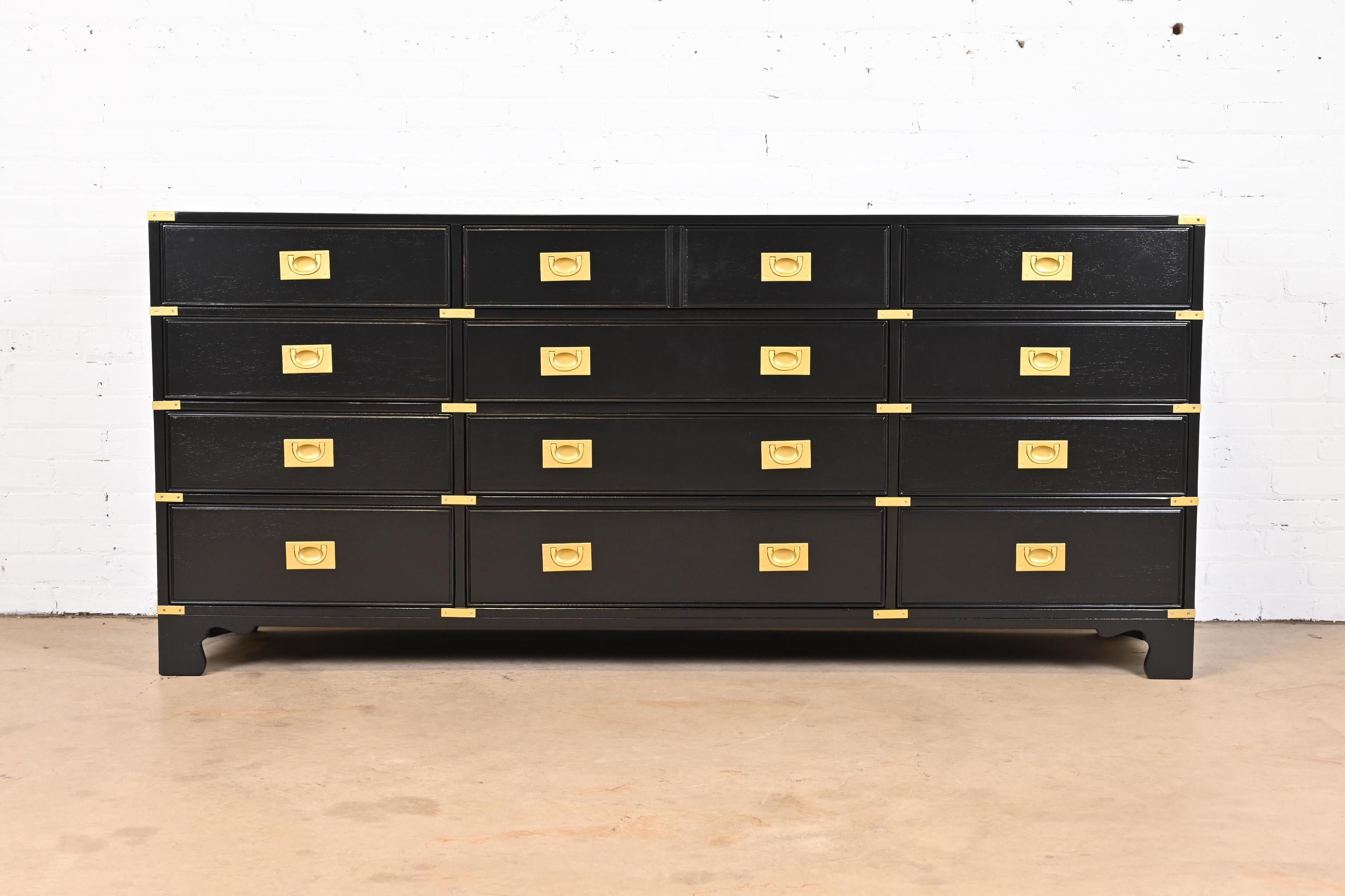 An exceptional mid-century modern Hollywood Regency Campaign style twelve-drawer dresser or credenza

By Drexel Heritage

USA, 1970s

Black lacquered walnut, with original brass hardware.

Measures: 76