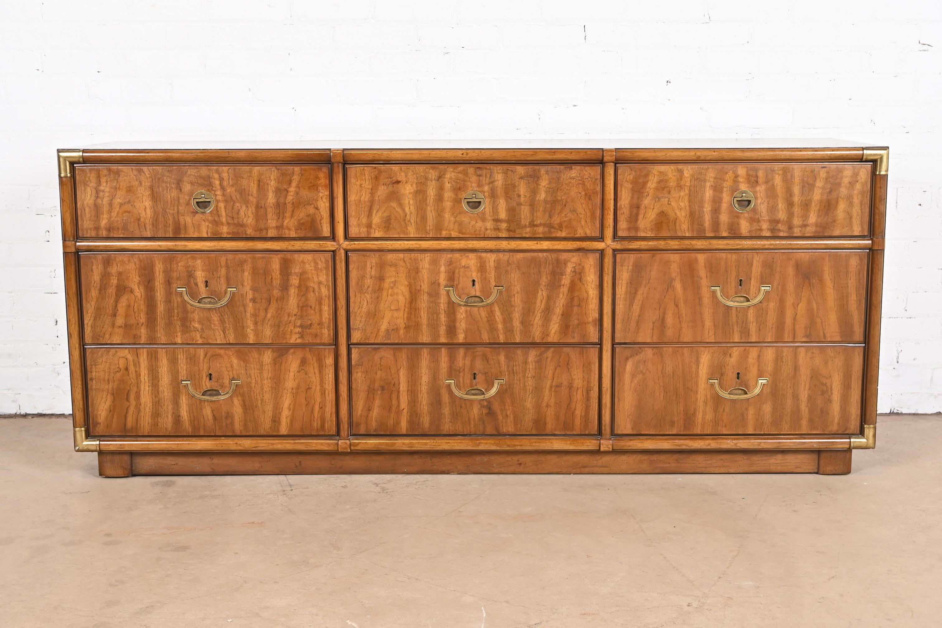 A gorgeous mid-century modern Hollywood Regency Campaign style nine-drawer dresser or credenza

By Drexel Heritage

USA, 1970s

Walnut, with original brass hardware.

Measures: 70.5