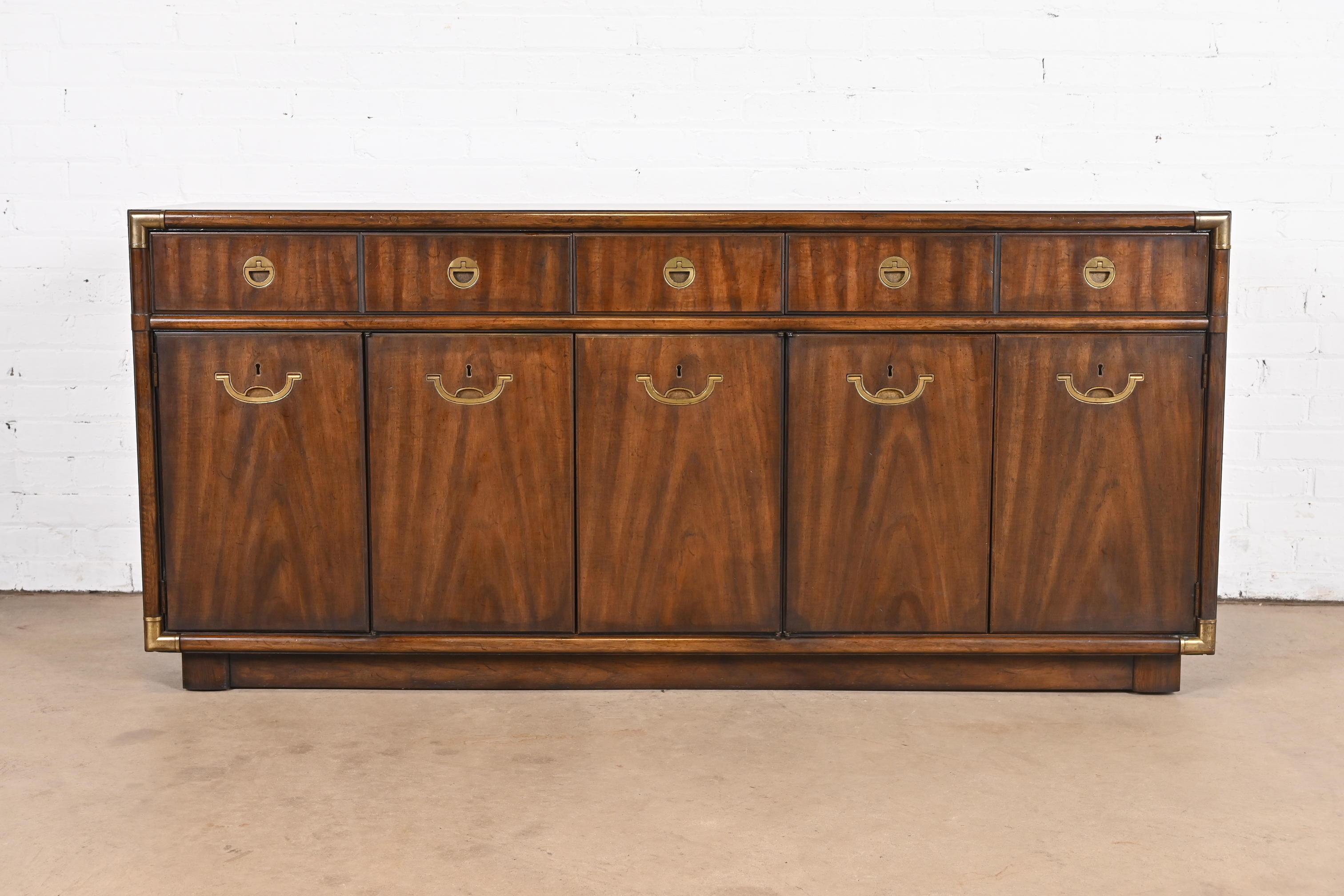 A gorgeous mid-century modern Hollywood Regency Campaign style sideboard, credenza, or bar cabinet

By Drexel Heritage

USA, Circa 1970s

Beautiful book-matched walnut, with original brass hardware.

Measures: 66.25