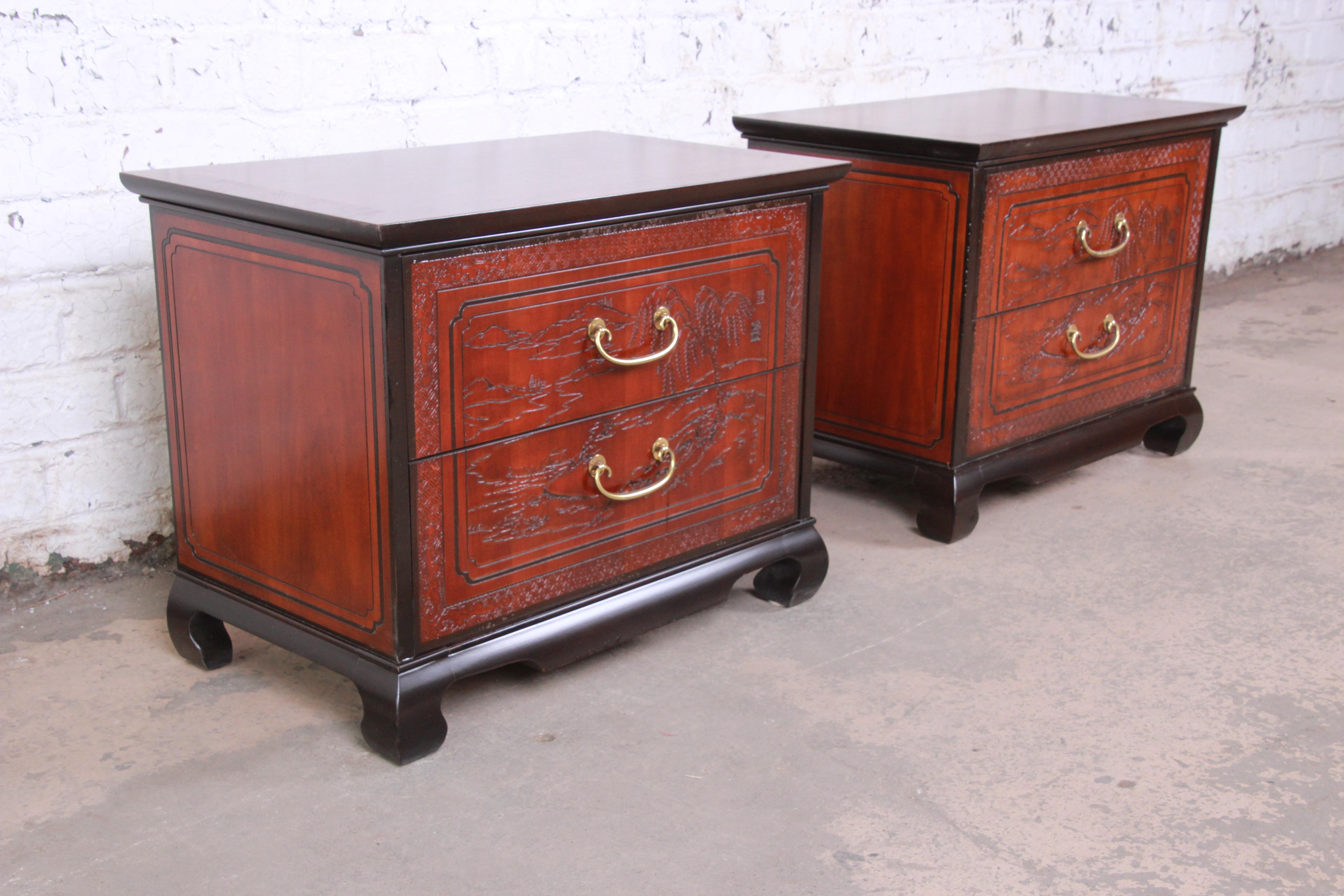 A gorgeous pair of midcentury Hollywood Regency chinoiserie nightstands

By Drexel Heritage

USA, circa 1970s

Book-matched banded mahogany, with carved Asian nature scenes, ebonized wood trim and legs, and original Asian-inspired brass