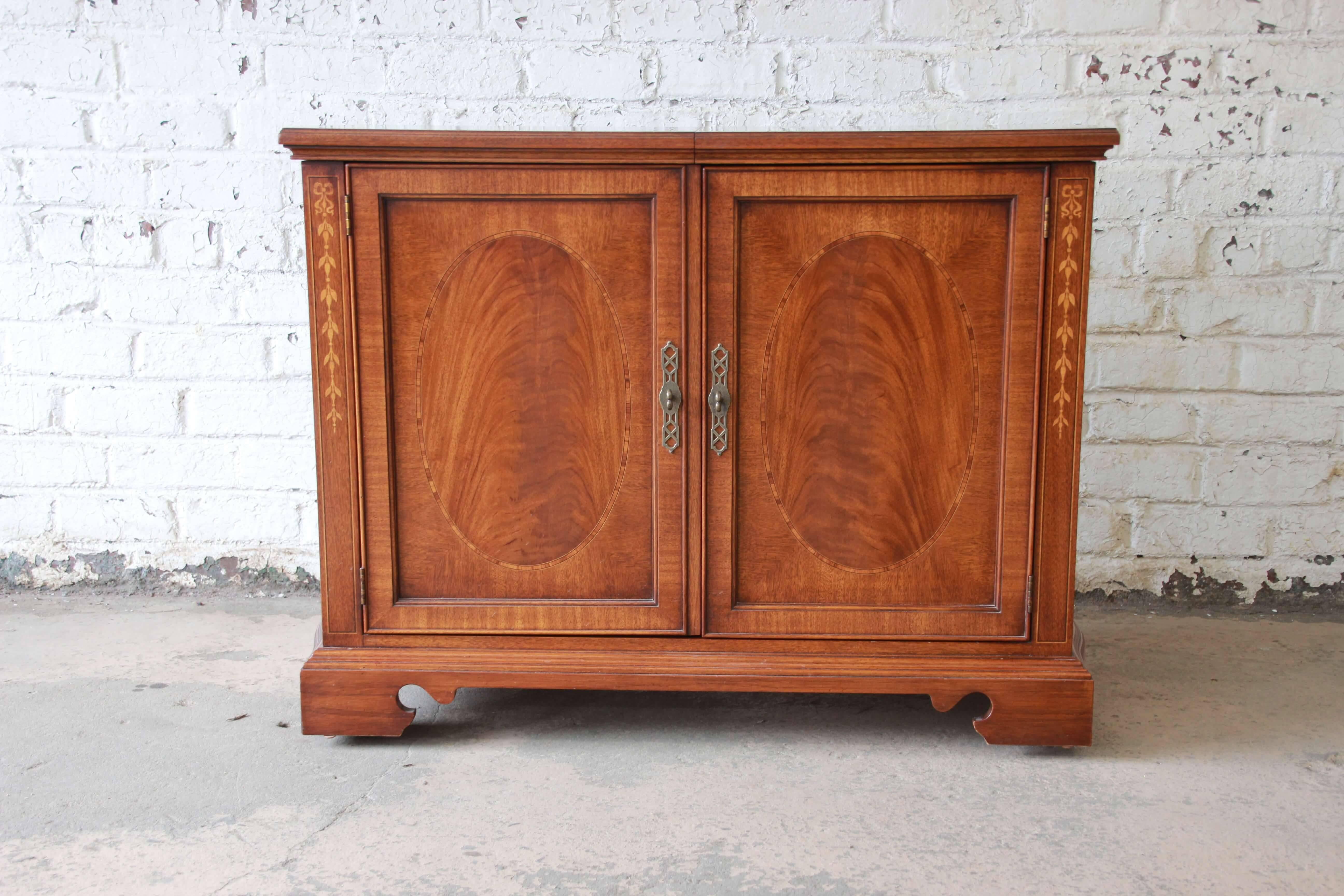 Offering a very nice vintage Drexel Heritage buffet, server or bar. The inlaid and flame mahogany server sits on smooth rolling casters. The top slides to reveal a black laminate extending the server to 65.63