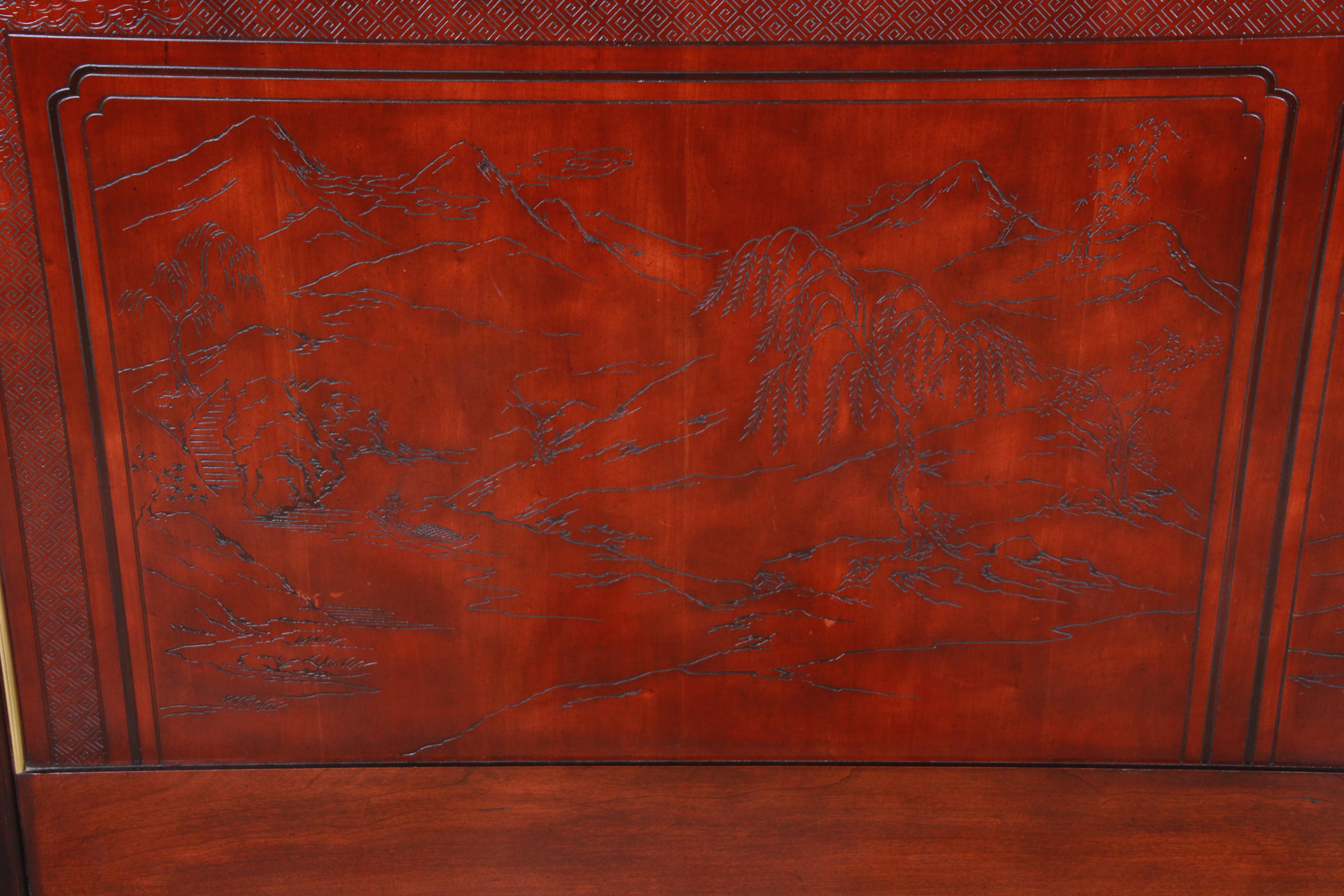 A gorgeous Hollywood Regency Chinoiserie queen size headboard from the Conoisseur line by Drexel Heritage. The headboard features beautiful mahogany wood grain with brass trim and unique carved Asian details with nature scenes. The original Drexel