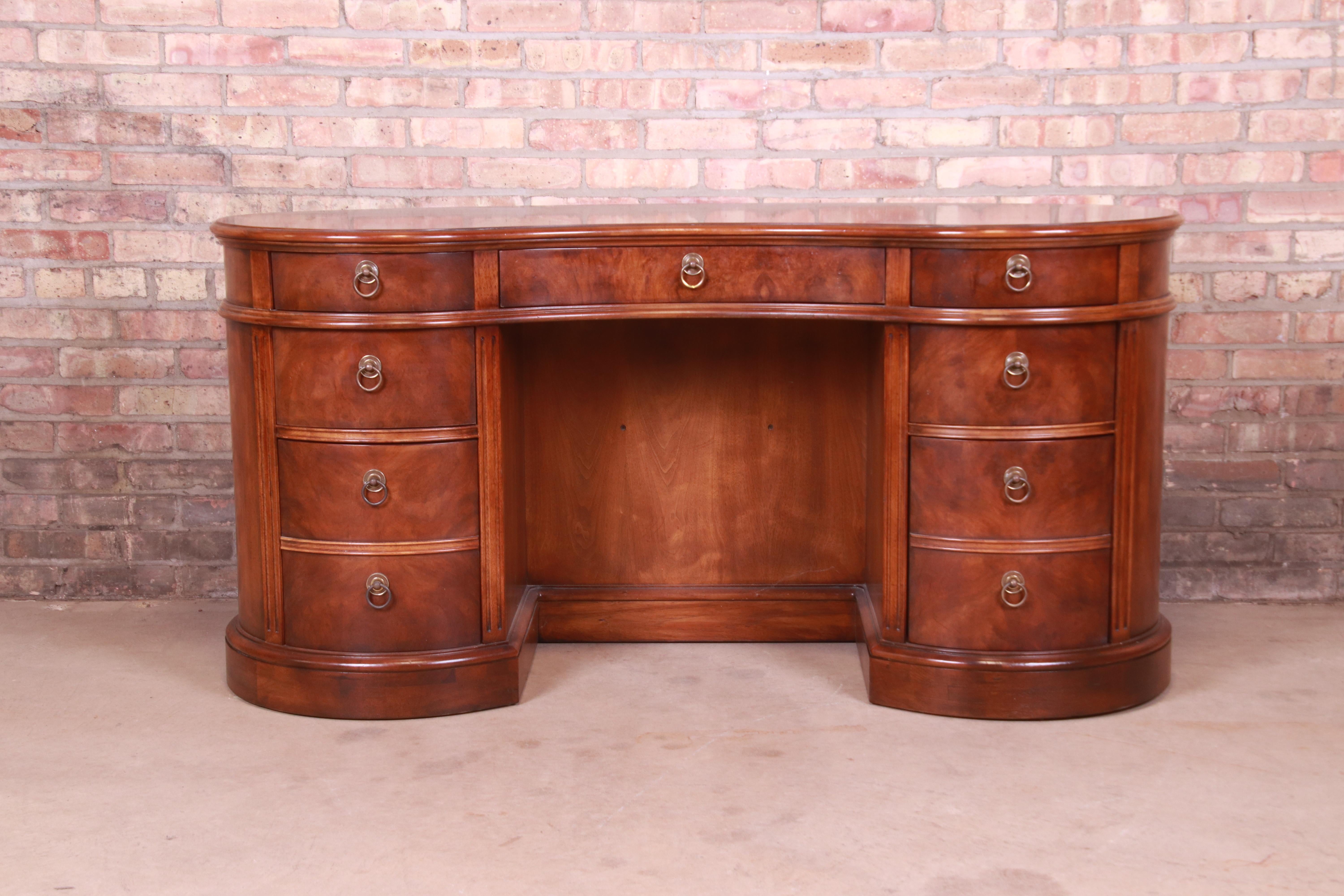 An exceptional Regency style kidney shaped writing desk with built-in bookcase

By Drexel Heritage

USA, Circa 1980s

Mahogany and burl wood, with original brass hardware.

Measures: 60