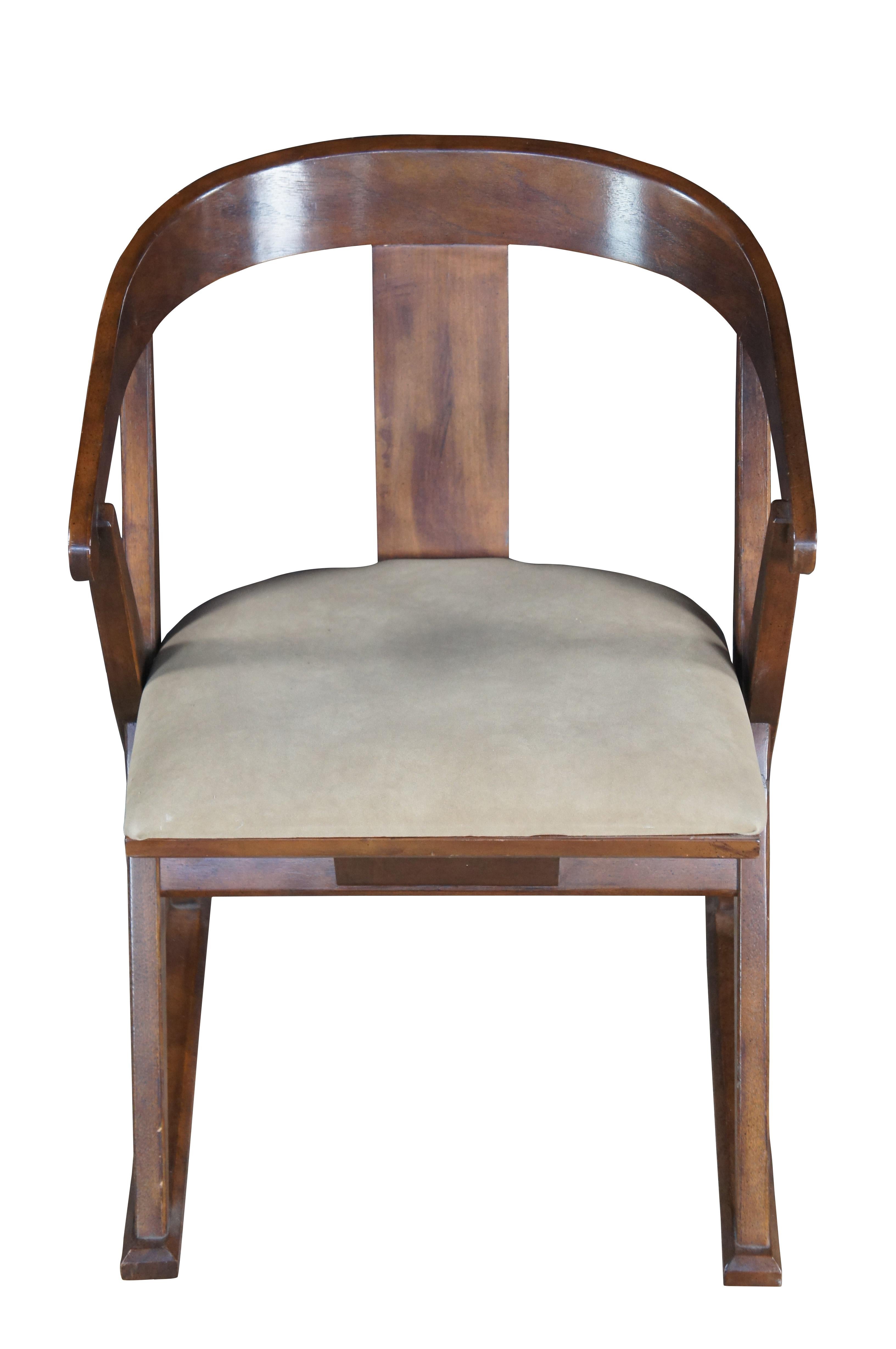 Sillón con brazos estilo campaña Drexel Heritage, hacia la década de 1970.  Presenta un acabado en nogal envejecido con respaldo curvado y marco en forma de 