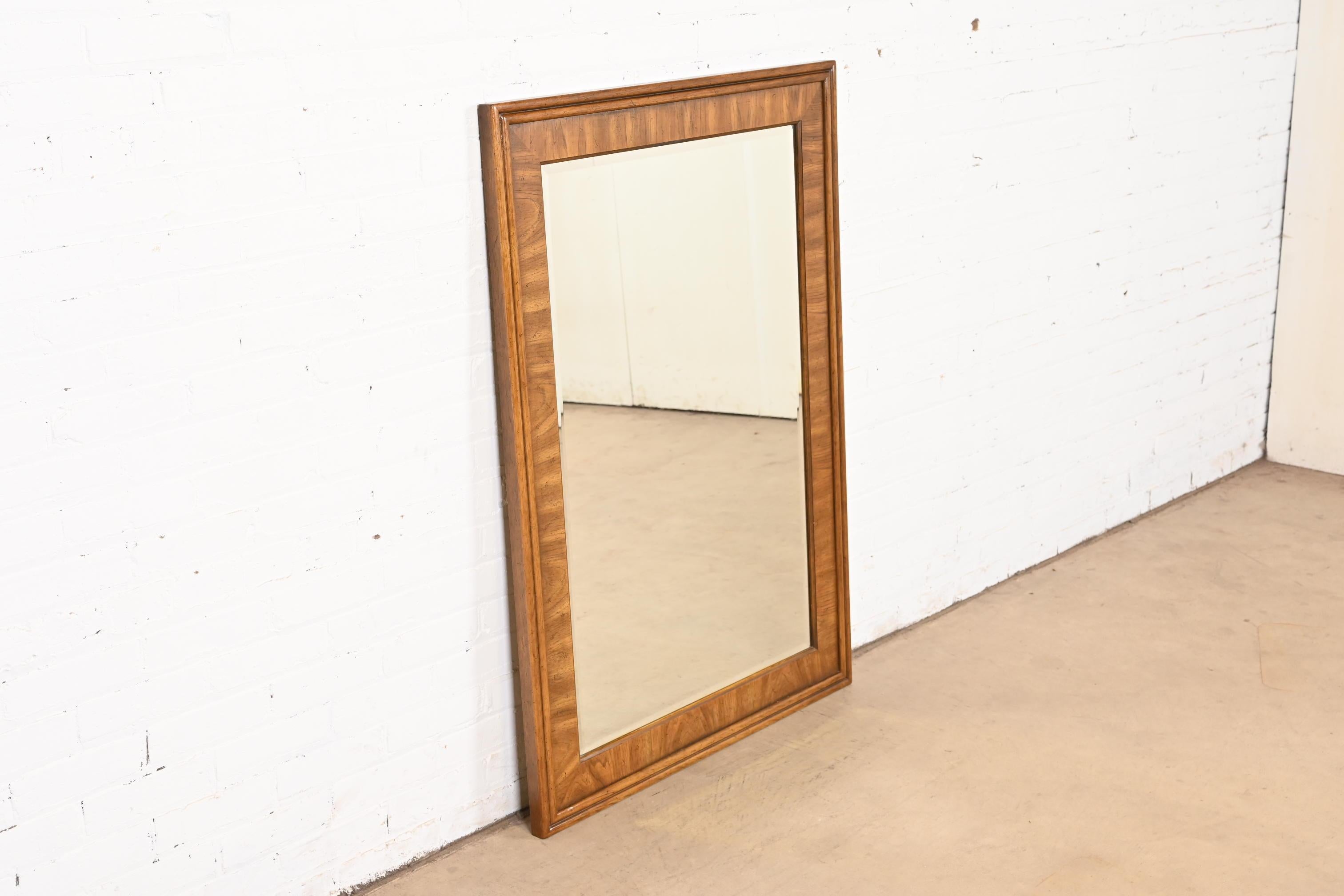 A gorgeous Mid-Century Modern walnut framed large beveled glass wall mirror

By Drexel Heritage

USA, Circa 1970s

Measures: 33.75