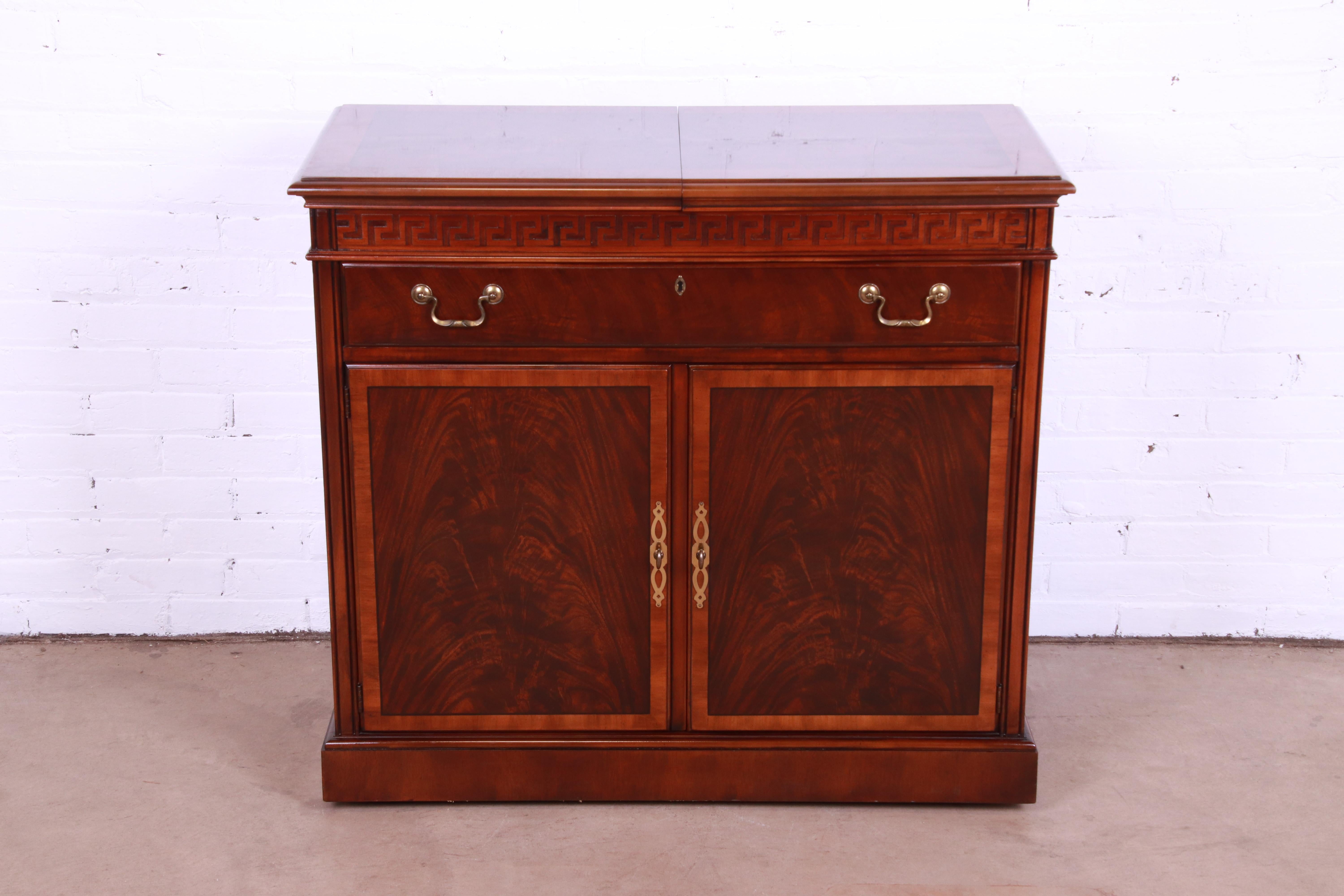 An exceptional Regency or Georgian style rolling server or bar cart with extending top

By Drexel Heritage

USA, Circa 1980s

Book-matched banded flame mahogany, with carved Greek key design and original brass hardware.

Measures: 38