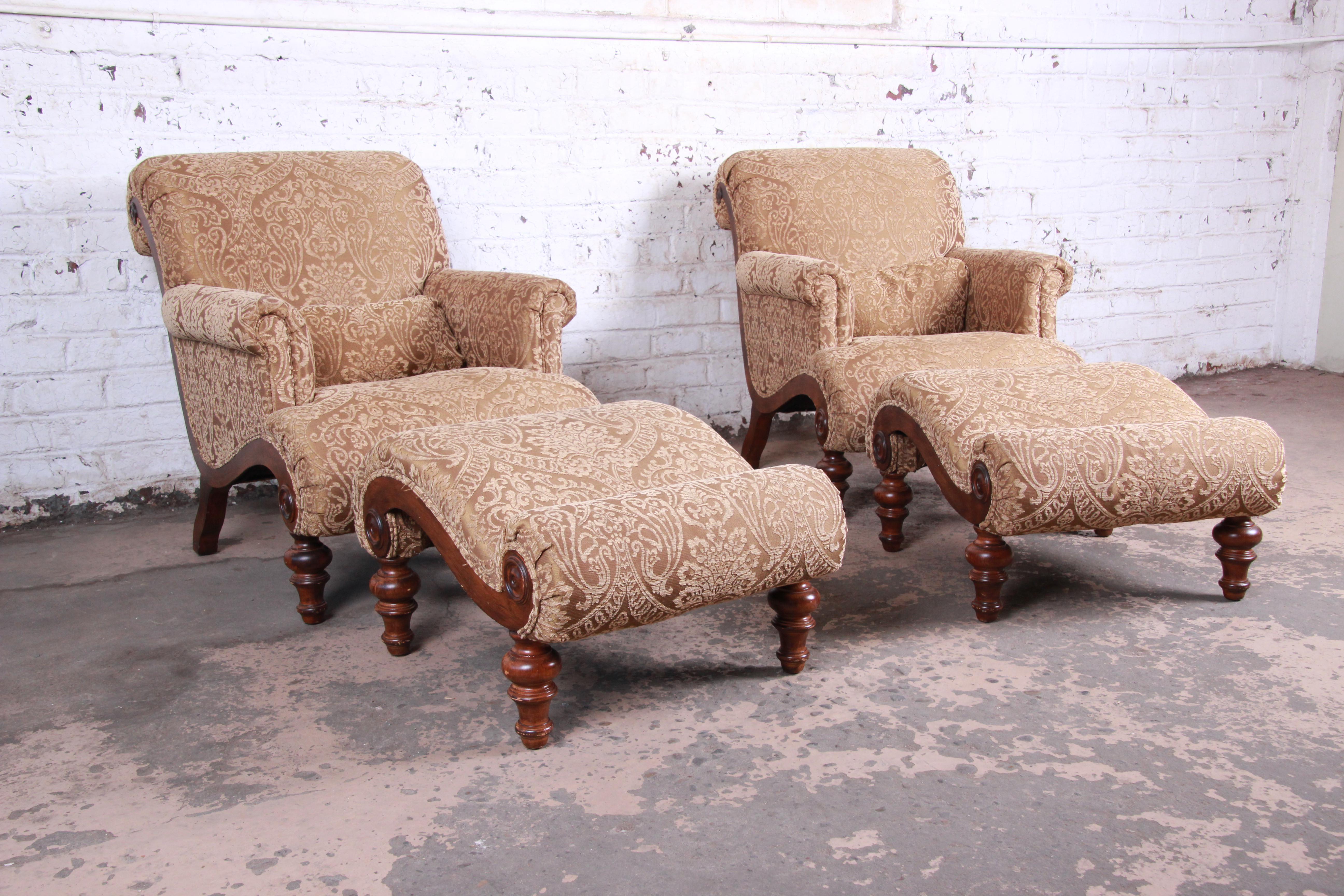 An exceptional pair of lounge chairs with ottomans by Drexel Heritage. The set features walnut legs and trim and beautiful tan damask upholstery. They have scrolled arms and seat backs and are very comfortable. The original labels are present. They