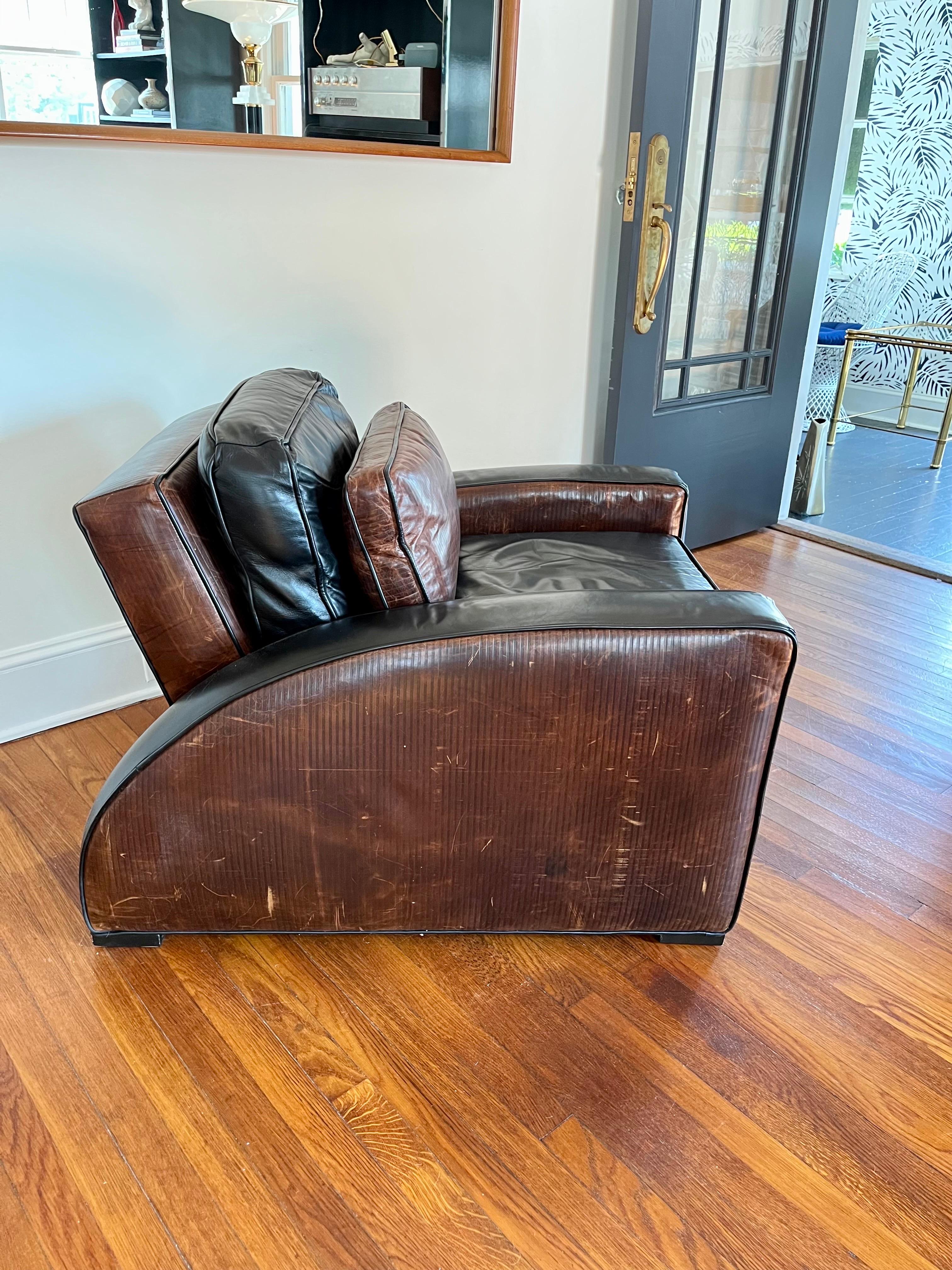 Wonderful art deco club chair and ottoman.WALT DISNEY SIGNATURE COLLECTION. Nicely detailed with two tone and textured leather. Soft subtle leather and back pillow. Sides with contrasting Vertical tool lined leather.
Ottoman measures