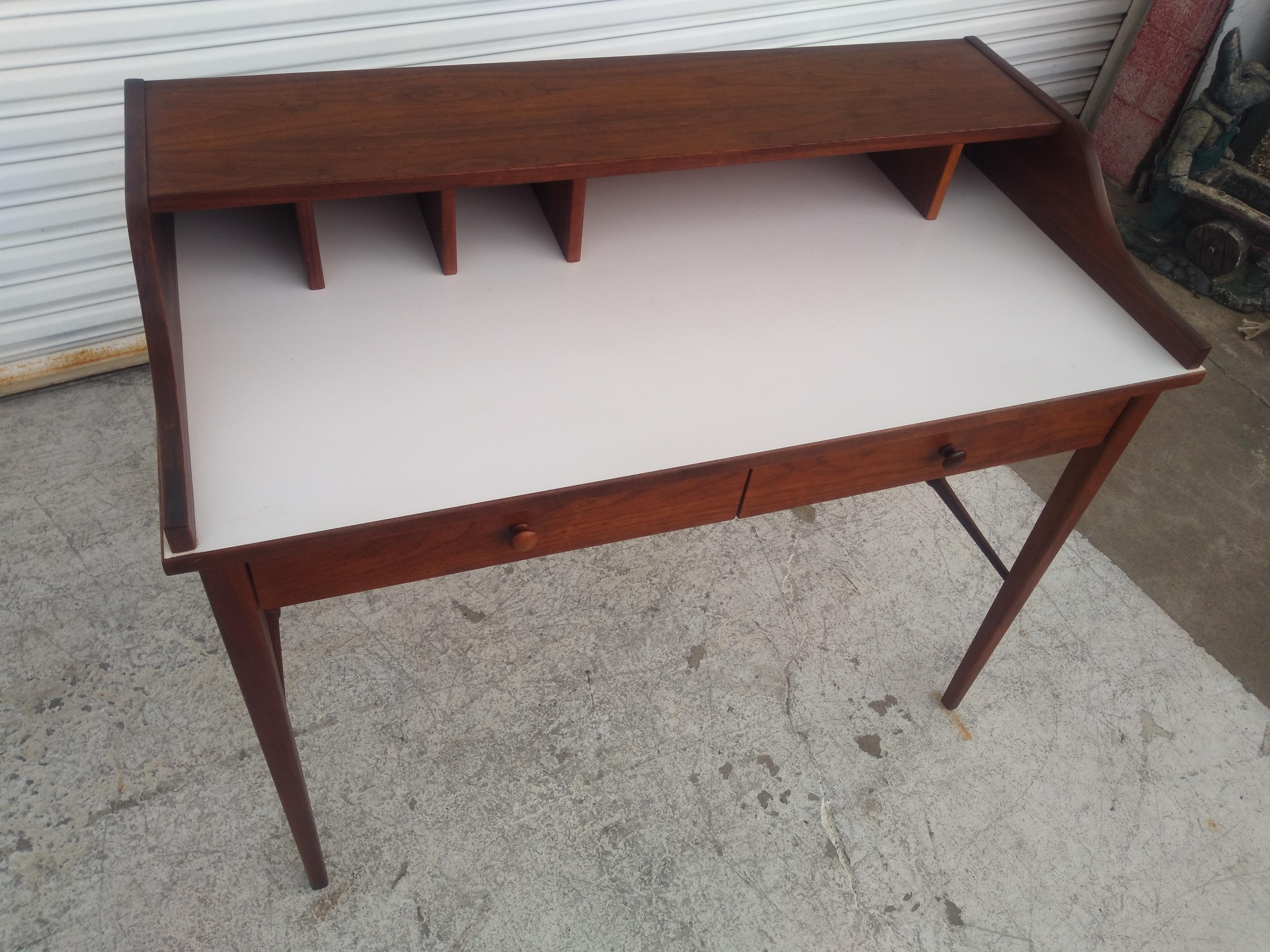 Questa è una splendida scrivania MCM di Drexel. Proviene dalla linea di mobili Biscayne. È realizzato in noce con una ricca venatura. Il piano è in laminato bianco e conferisce a questa scrivania un aspetto da MCM. La parte superiore presenta anche