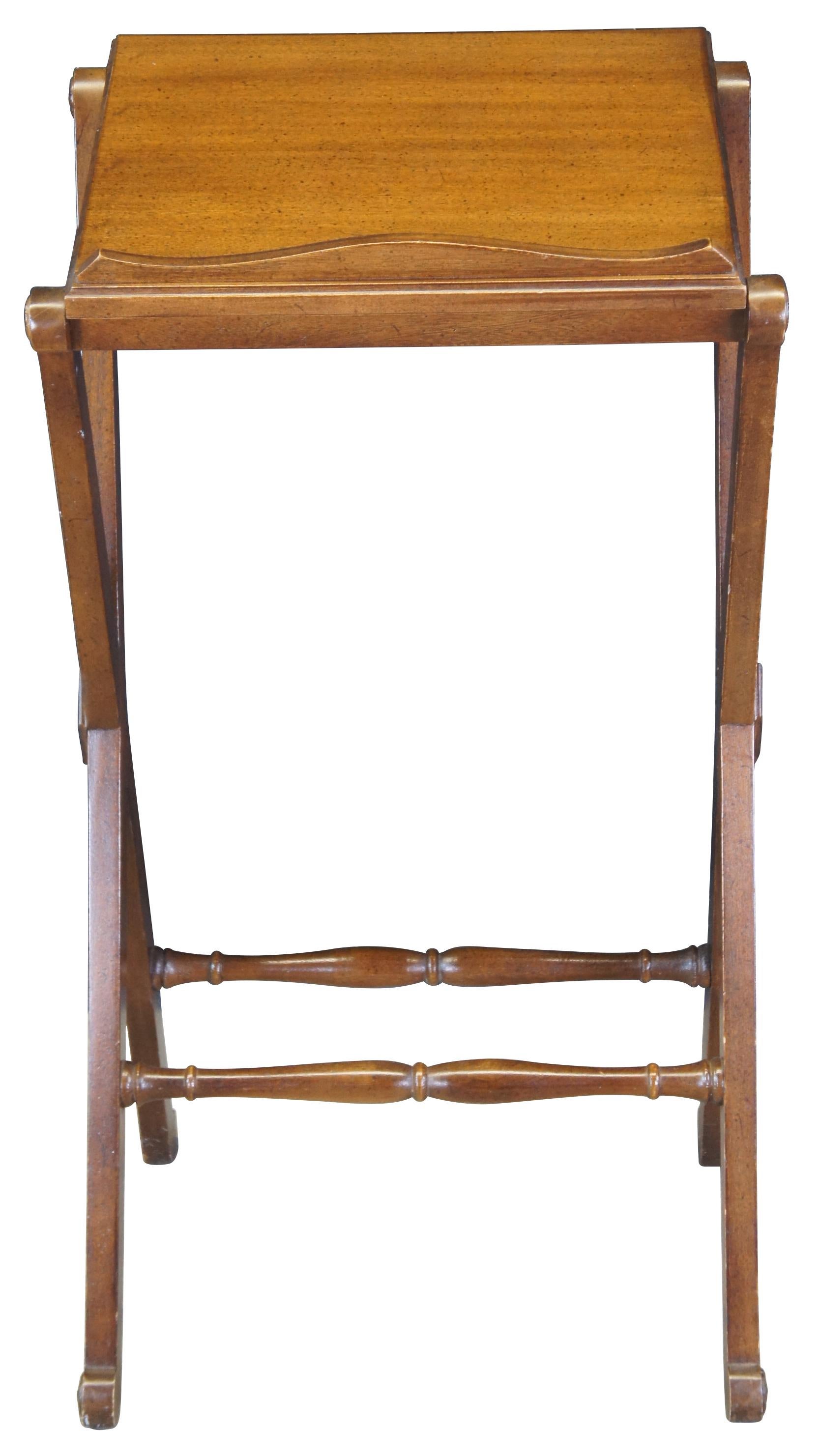 A vintage French inspired podium by Drexel, circa 1970s. Features a walnut-finished frame with an inclined surface showing a serpentine lipped bottom on an a pair of X-shaped supports joined by two baluster stretchers. The underside of the podium’s