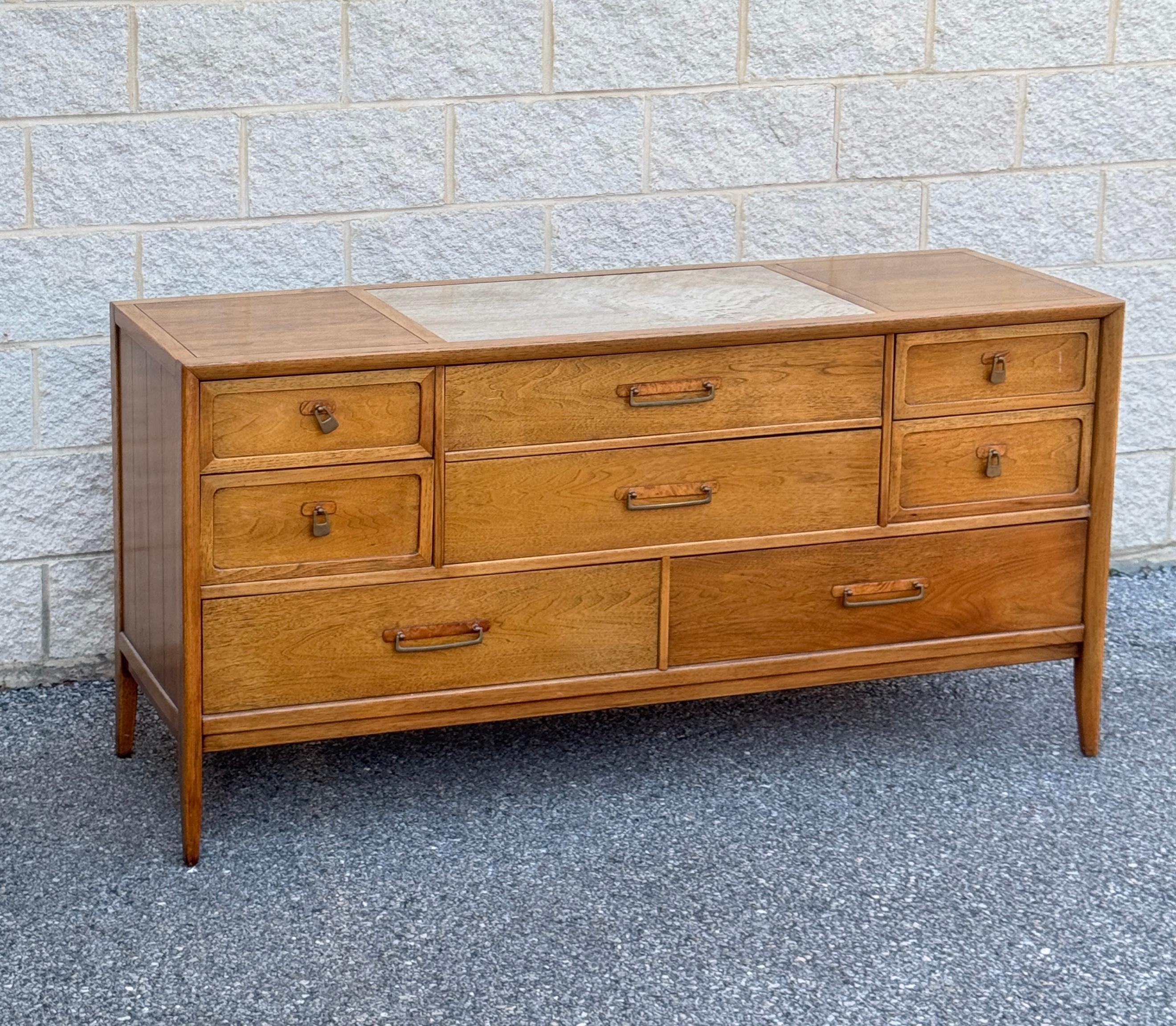 Comò Drexel d'epoca, un vero capolavoro della modernità di metà secolo. Realizzato in legno di noce di alta qualità con una finitura calda e ricca, questo mobile degli anni '60 è caratterizzato da linee eleganti, da eleganti tiranti incassati e da