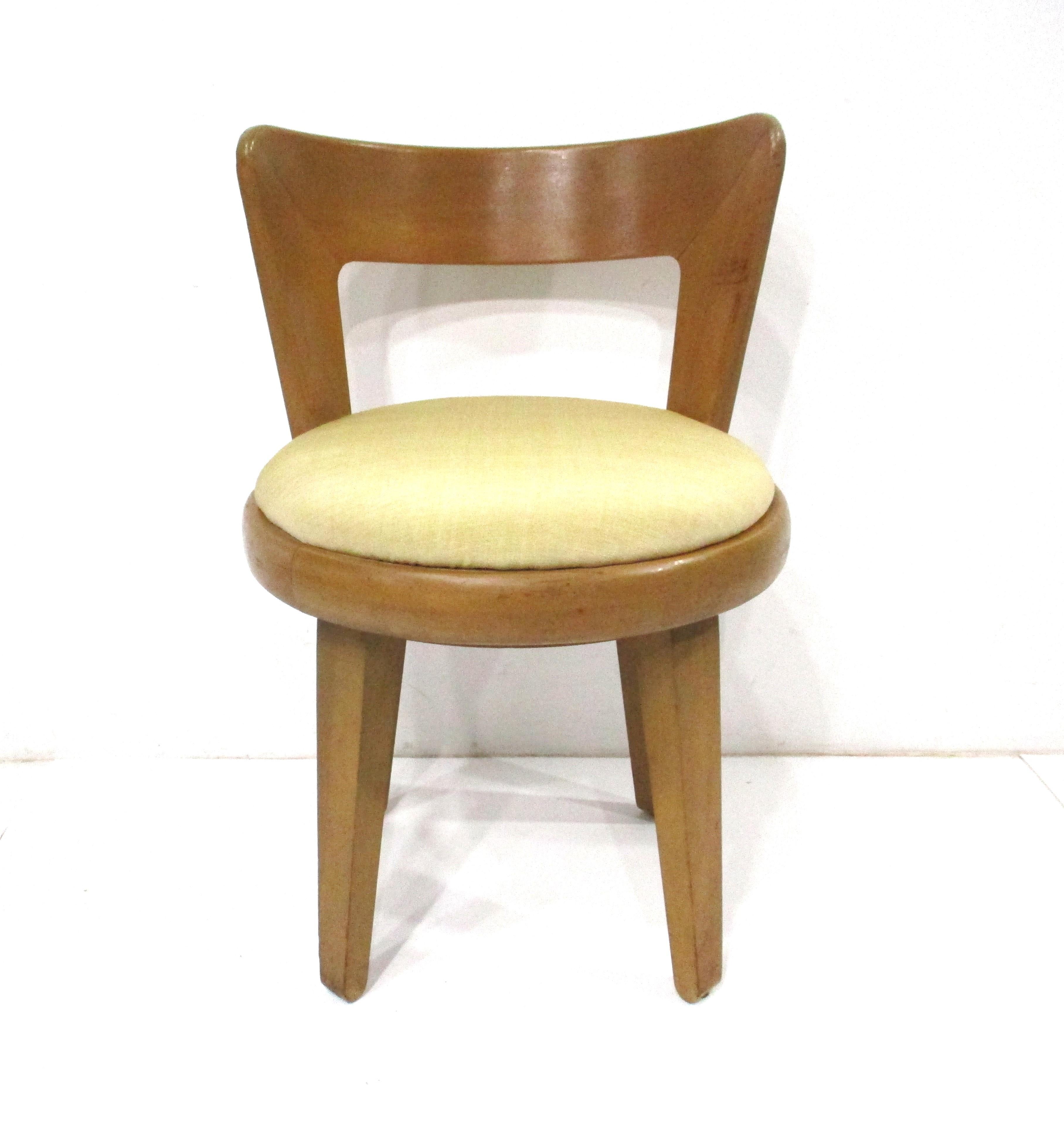 A swiveling maple wood vanity stool with sculptural curved back and upholstered seat cushion . Designed by Edward Wormley who's work for the Dunbar furniture company are well known styled this stool for Drexel's Precedent collection in the 1950's .