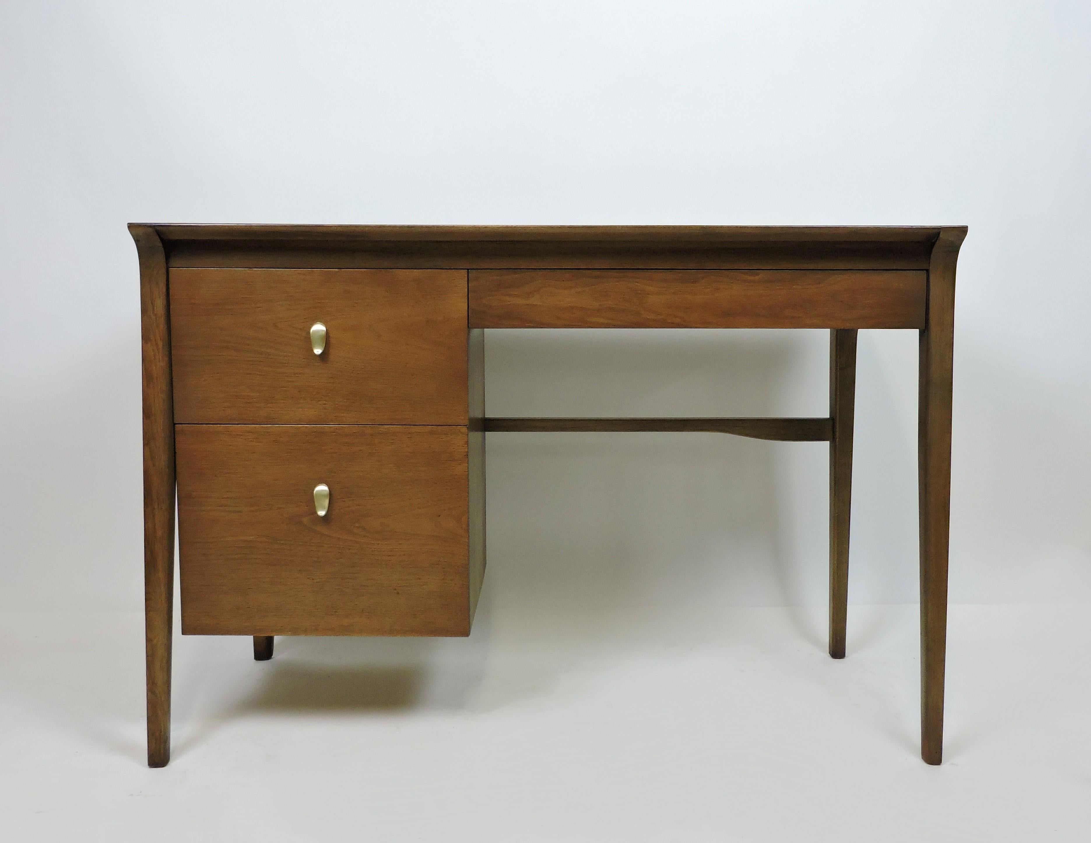 Elegant Mid-Century Modern K95 desk in walnut designed by John Van Koert for high quality furniture maker, Drexel. This desk has two large drawers on the left, and a smaller drawer on the right. The lower drawer has rails for hanging folders and the