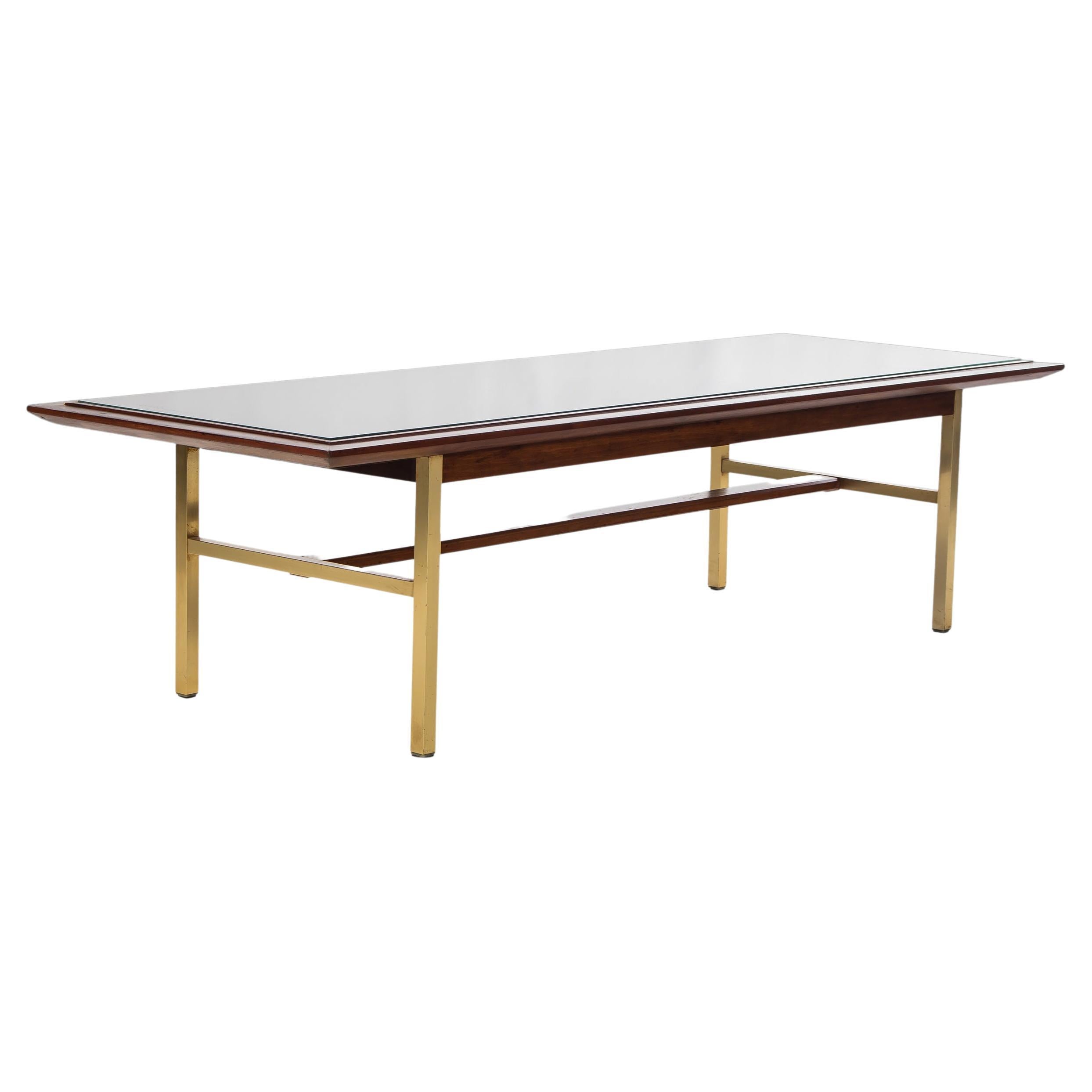 Produced by Drexel Sun Coast this coffee table, designed by Kipp Stewart & Stewart McDougall, is an exquisite example of early American mid-century design and craftsmanship. With solid walnut wood grains, luxurious brass legs and a fabulous cane top