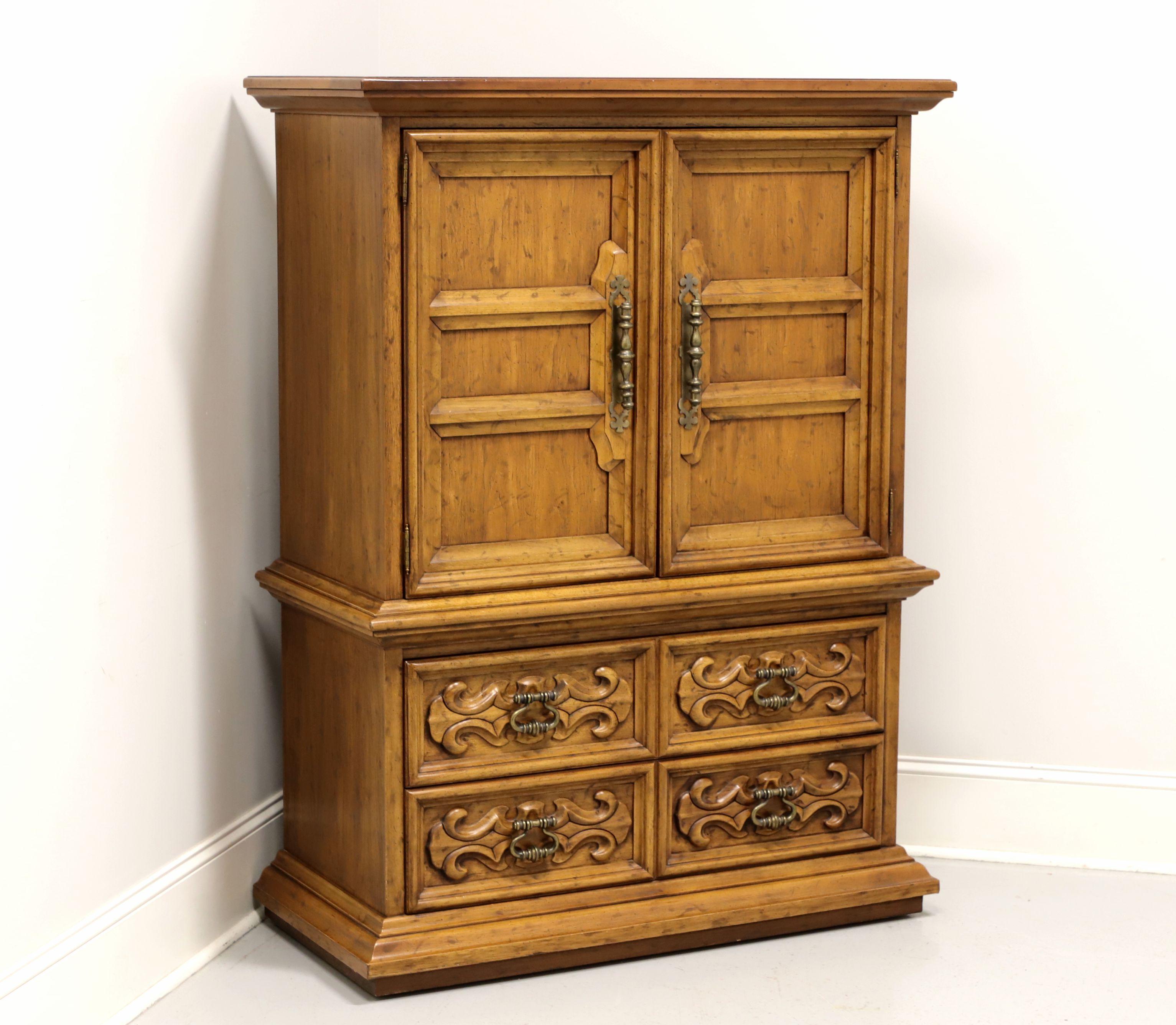 A Spanish style gentleman's chest by Drexel, from their Velero Collection. Pecan with a distressed finish, brass hardware, carved door and drawer fronts. Features upper section with dual doors revealing upper shelf and three dovetail drawers. Lower