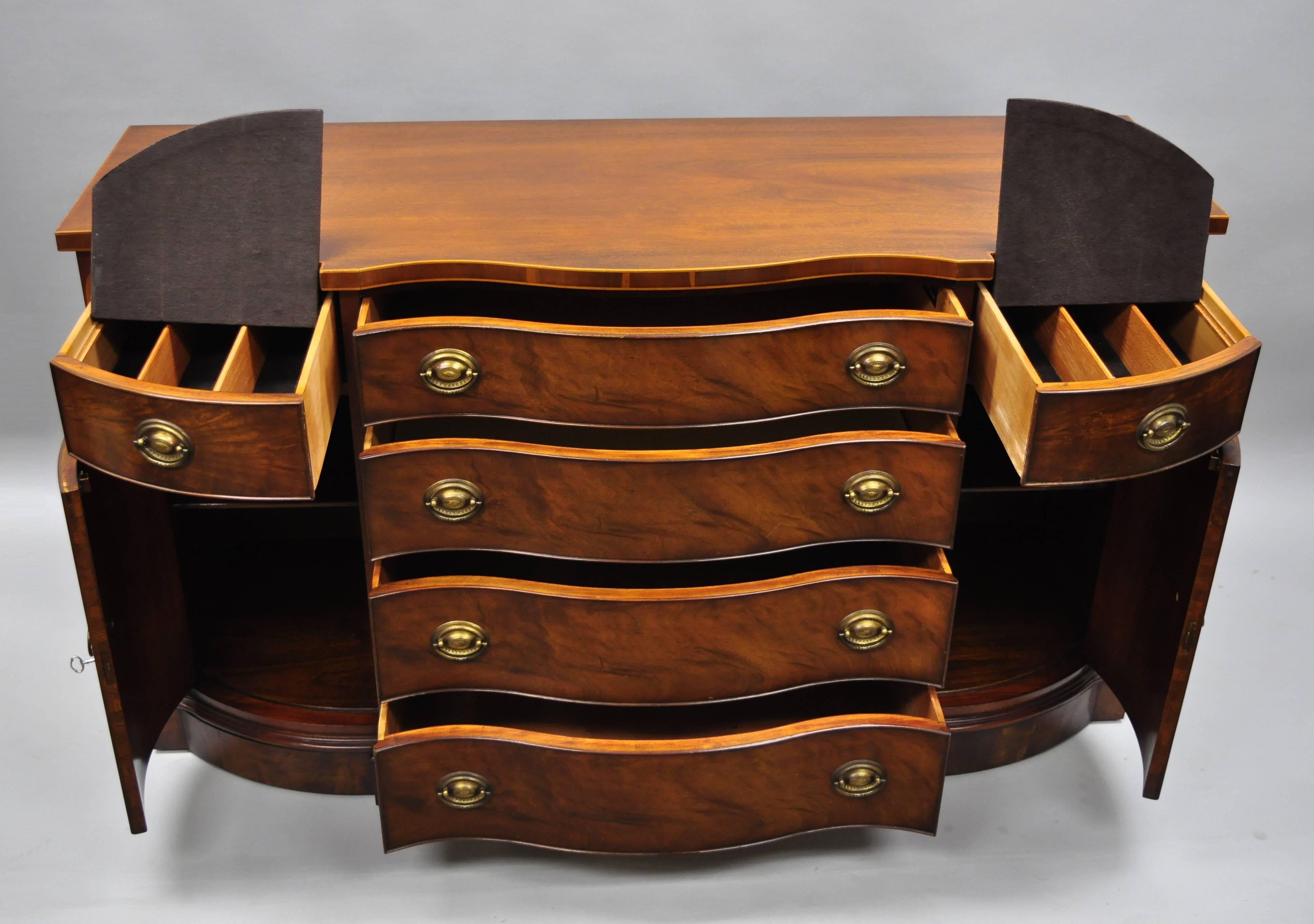 Drexel Wallace nutting serpentine front mahogany sideboard buffet. Item details shell and spiral satinwood inlay, beautiful wood grain, two swing doors, original label, working lock and key, six dovetailed drawers, two wooden shelves, quality
