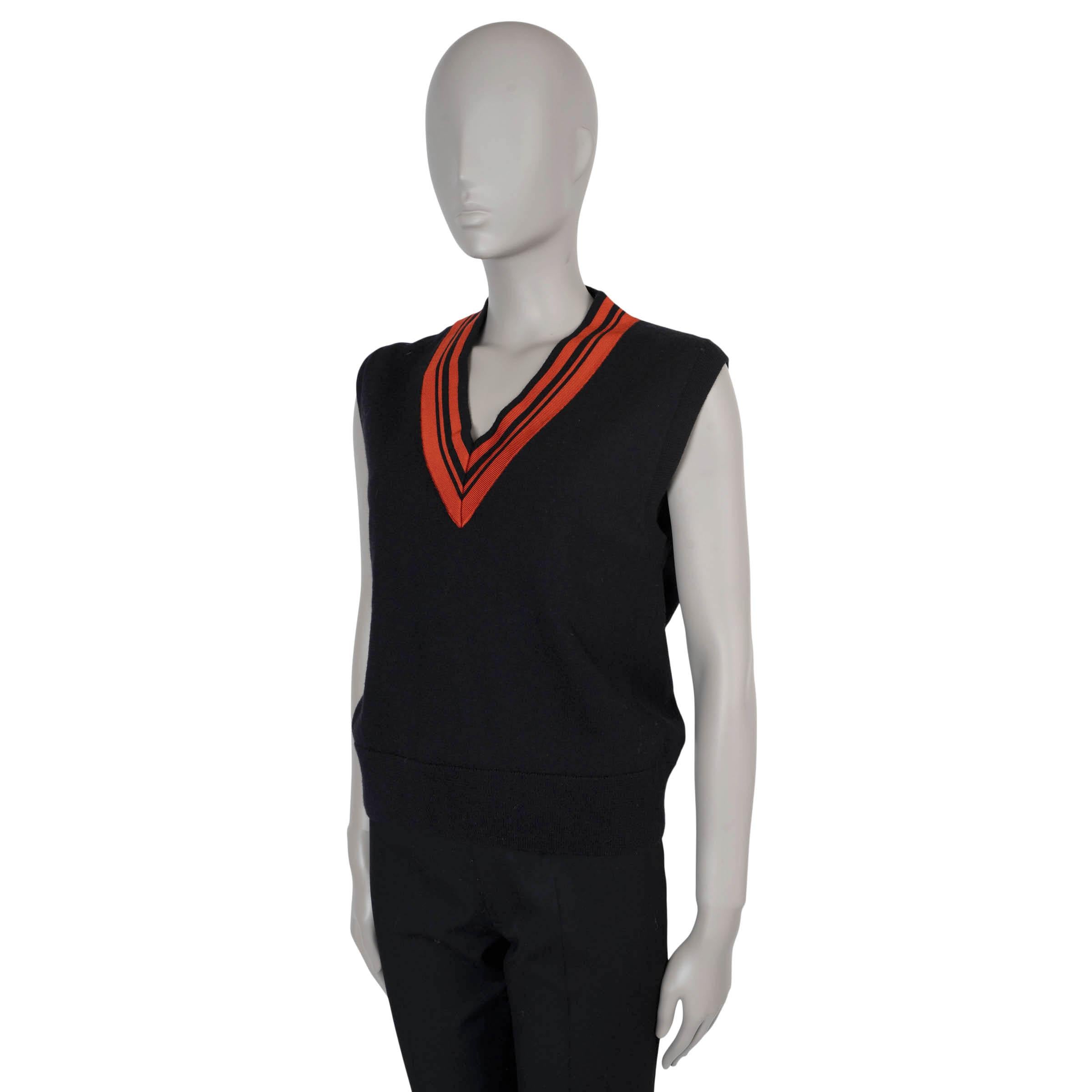 This 100% authentic Dries van Noten sweater vest is crafted from black merino wool (95%) and viscose (5%) for a soft, luxurious feel. It features a bold red striped cricket V-neck, adding a striking contrast to the classic design. Perfect for