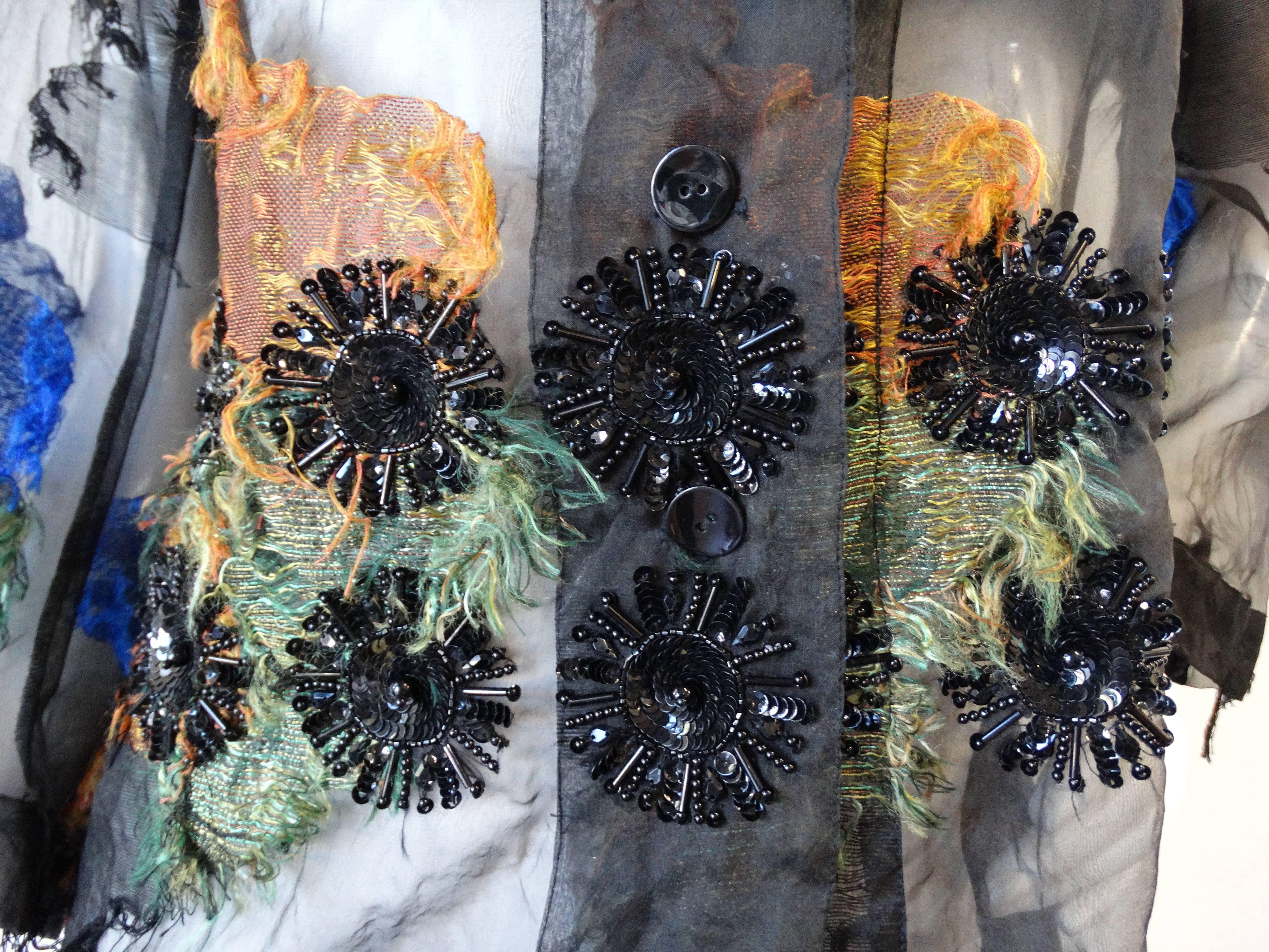 Don't miss out on this amazing Dries Van Noten embellished blouse! Made of a sexy sheer black fabric with patches of blue, green and orange embroidery, each with various distressing texture. Two rows of mandalas of black floral-like beading around