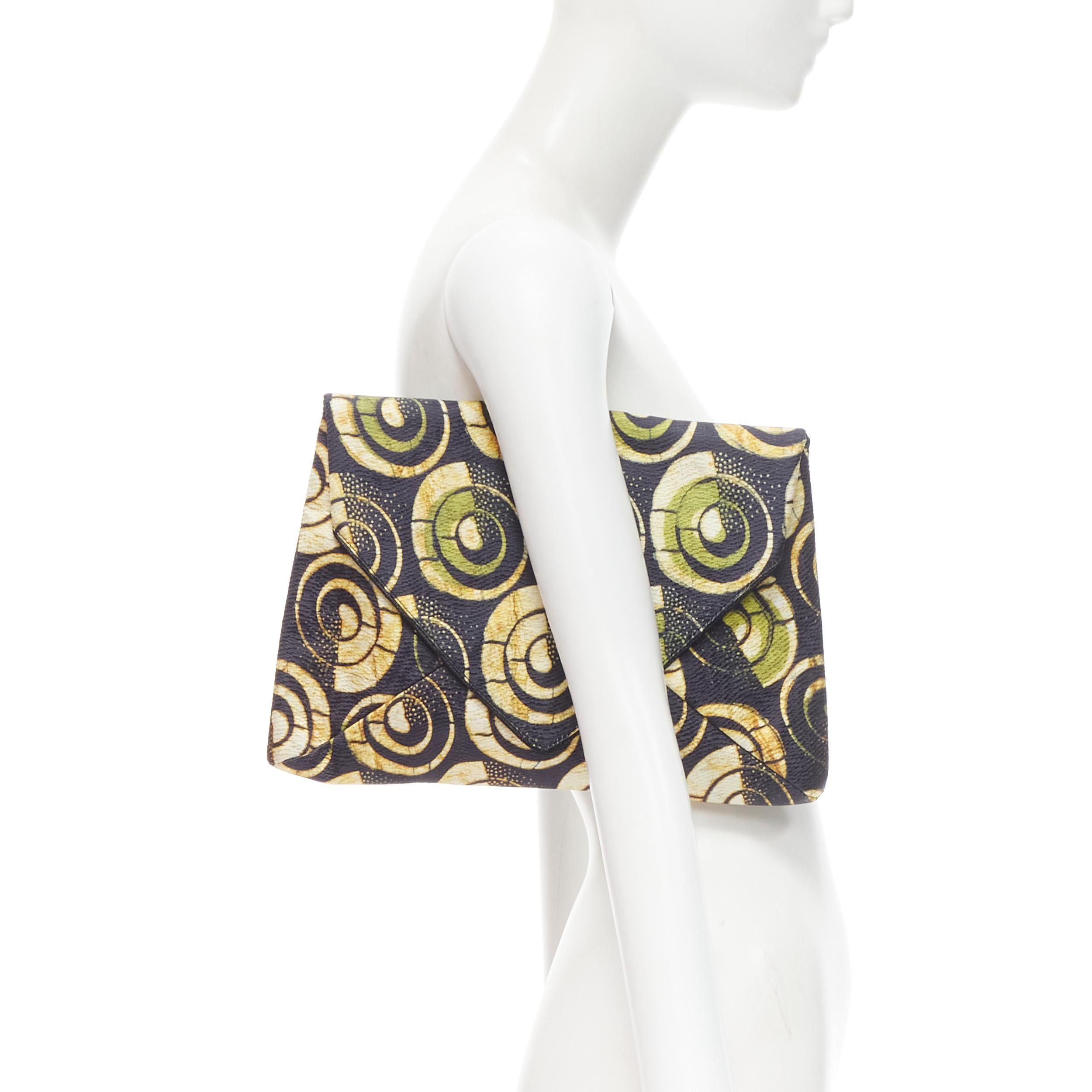 DRIES VAN NOTEN black yellow ethnic geometric swirl envelope clutch bag
Reference: CELG/A00047
Brand: Dries Van Noten
Designer: Dries Van Noten
Model: Ethnic print envelope clutch
Material: Fabric 
Color: Orange
Pattern: Abstract
Closure: Magnet