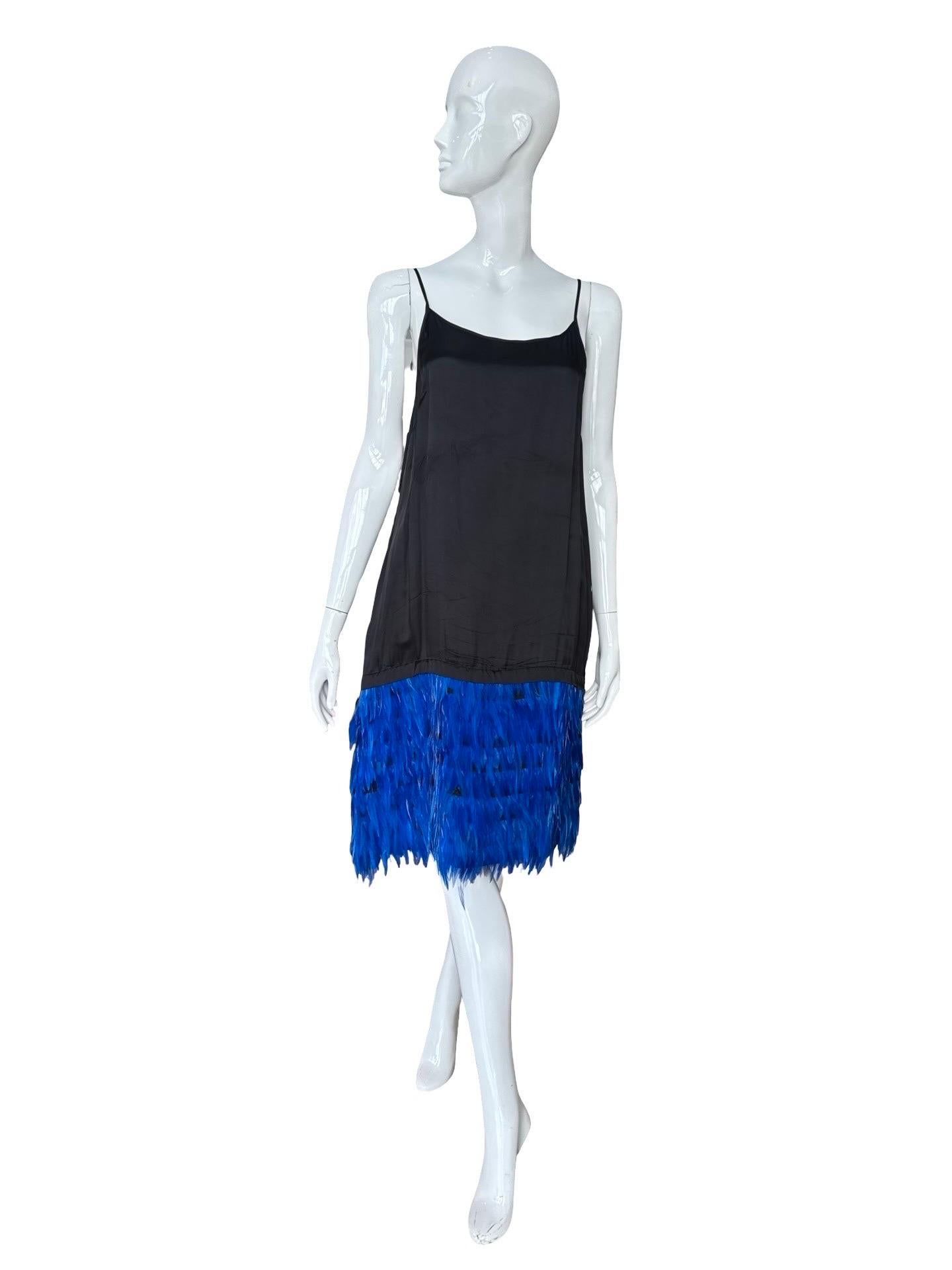 Unworn Dries van Noten pull on slip dress in a black viscose fabric with electric blue feathers tiered along the bottom hem.  This dress has a quite up and down fit and round neck line.  This could be worn on its own, or an excellent layering piece,