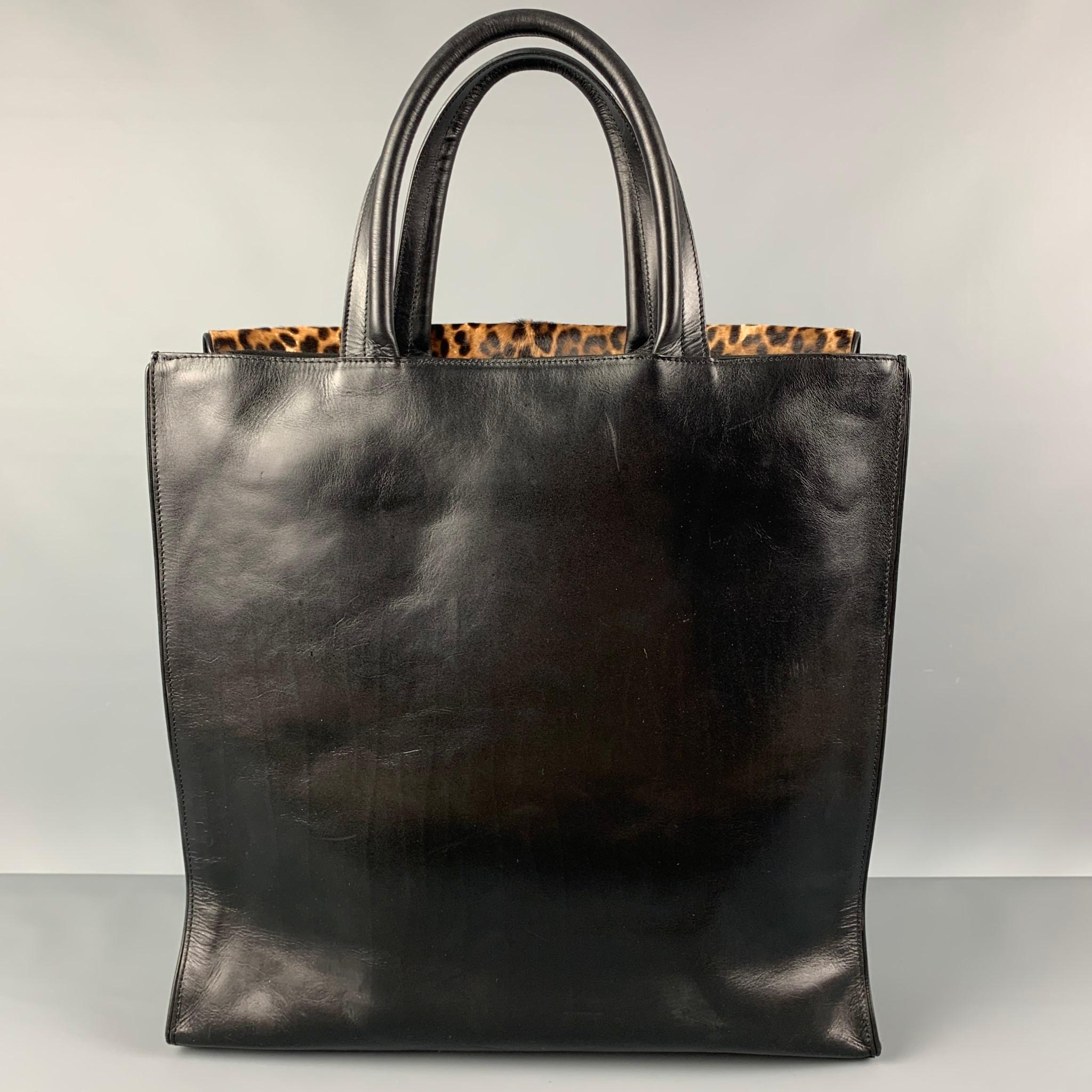 DRIES VAN NOTEN bag comes in a brown & beige animal print ponyhair and a black leather panel featuring top handles, front flap pocket, and interior double zip pockets. Includes dust bag.

Very Good Pre-Owned Condition.

Measurements:

Length: 15