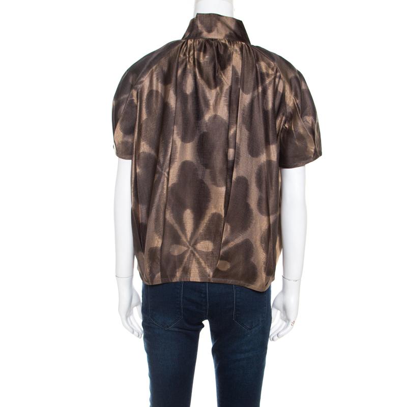 Lovely and stylish, this top from Dries van Noten is one creation you definitely need to get your hands on! The brown creation is made of 100% silk and features a lovely print all over. It flaunts a plunging neckline and short sleeves. Pair it with