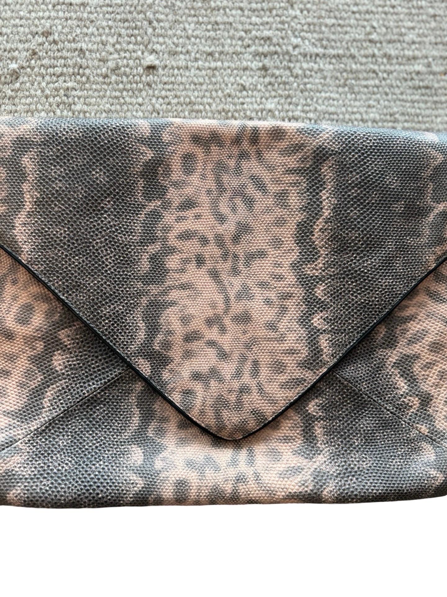 Pochette enveloppe classique de Dries van Noten en cuir souple rose et gris gaufré façon lézard. Les passepoils et le cuir intérieur sont noirs.  Fermeture aimantée et poche zippée au dos.  Excellent état, aucun défaut à noter. 

11
