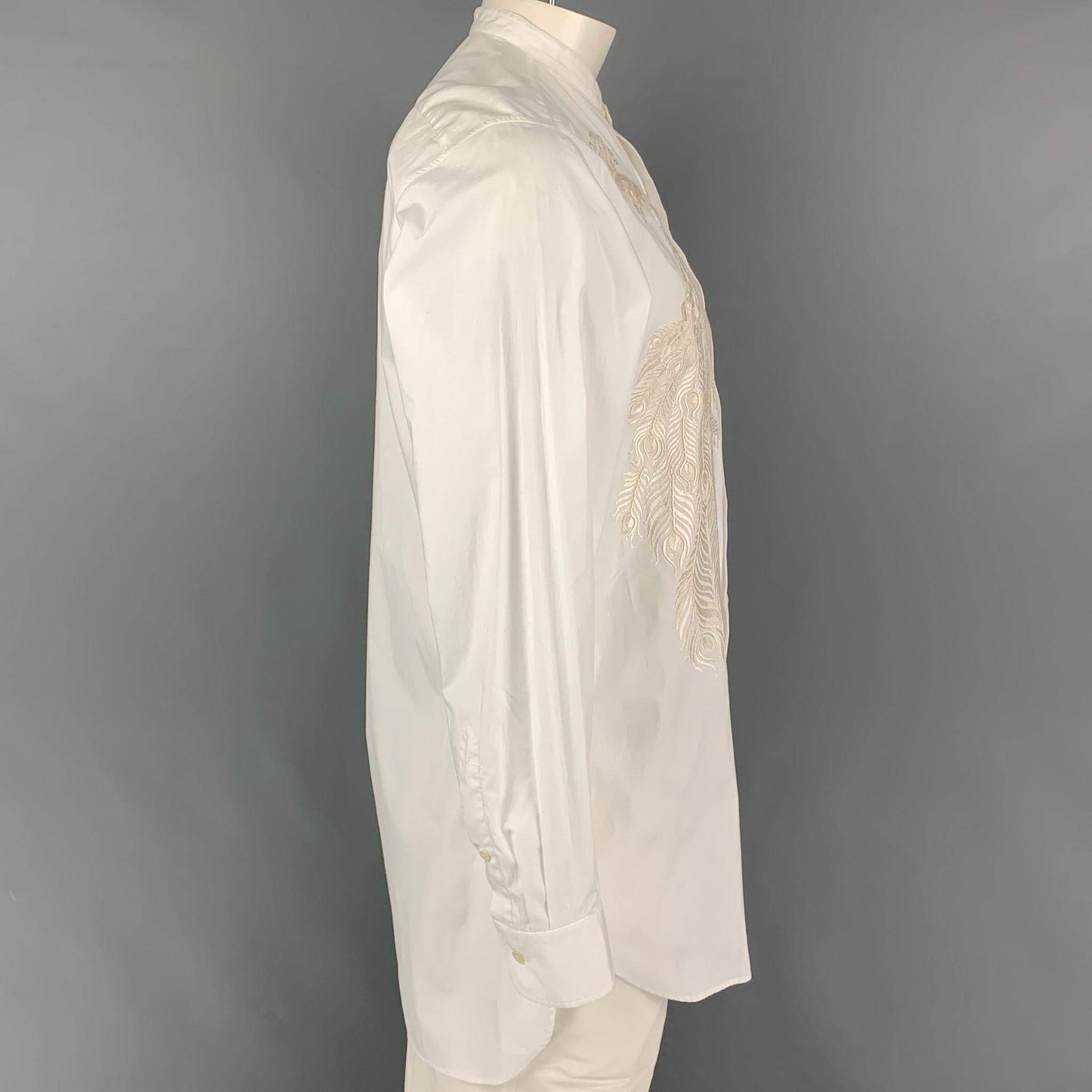 DRIES VAN NOTEN FW 16 long sleeve shirt comes in a white cotton featuring a nehru collar, front beige peacock embroidered design, and a button up closure. 

Very Good Pre-Owned Condition.
Marked: 50
Original Retail Price: