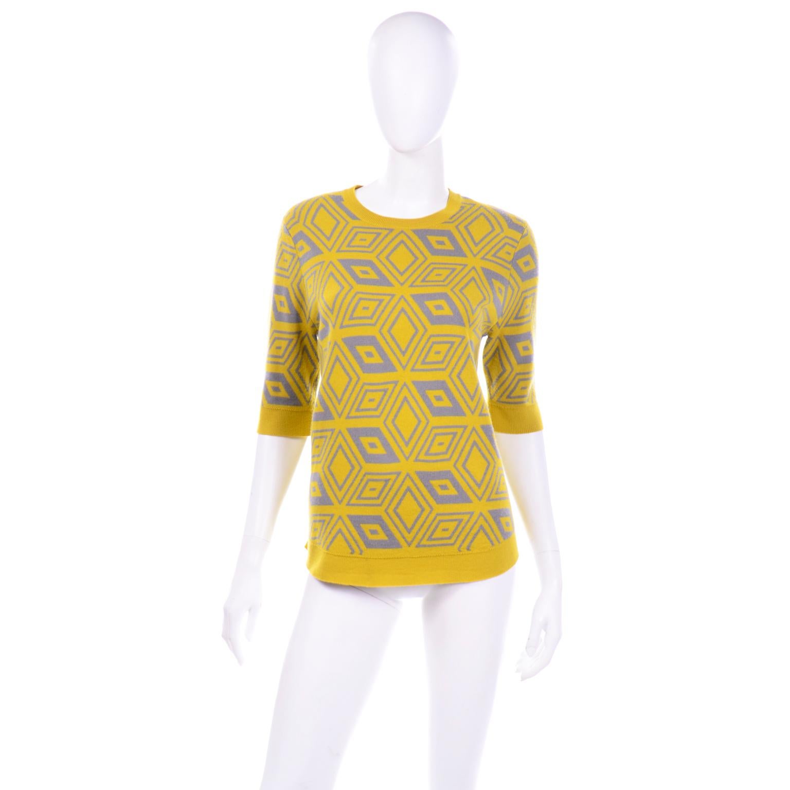 This is a  really fun Dries Van Noten yellow lime green and grey abstract printed wool sweater top with elbow length sleeves and a rounded collar. The abstract print is almost like a kaleidoscope pattern and the color combination adds a lot of