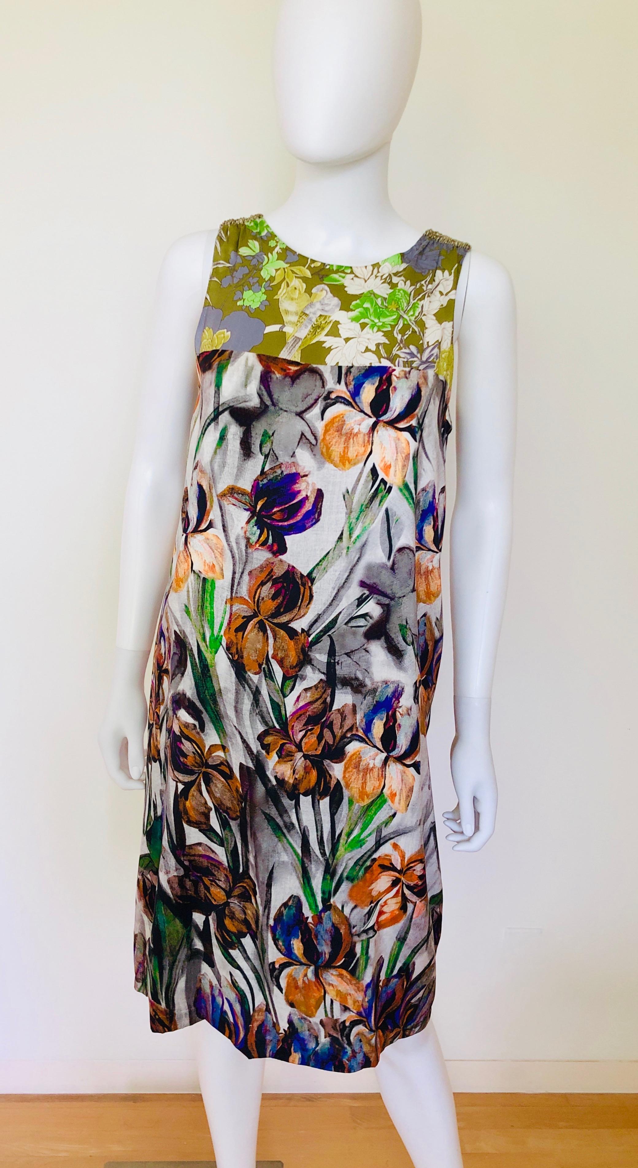 Offered is a signed Dries van Noten multicolored (green, blue, purple, orange, gray, black & white) floral pattern on tropical bird pattern sleeveless sheath day into evening dress with shoulder embellishments.  
Dries Van Noten / French size