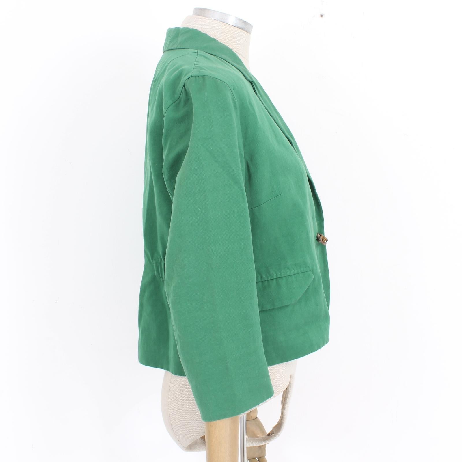 This vintage Dries Van Noten blazer is a unique and stylish addition to any wardrobe. Made with a blend of linen and cotton, it features a striking frog closure and brown and bronze beaded details on the side. The elastic waistband and 3/4 length