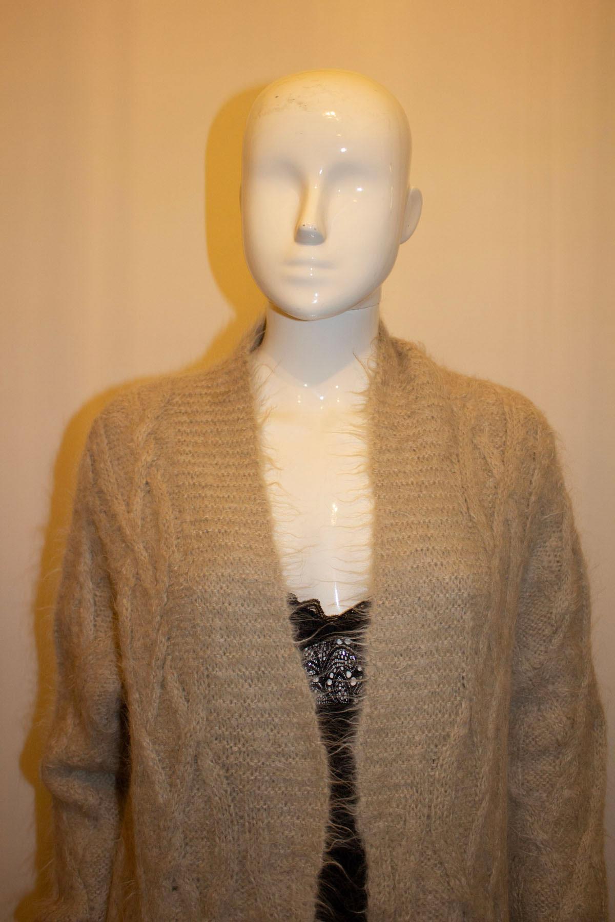 Perfect for Spring winds, this easy to wear knitted cardigan/ jacket by Dries van Noten is ideal for layering. In a pretty taupe with great knit detail, the jacket has no fastening but one could  be added. Measurements: Bust up to 44'', length 37''