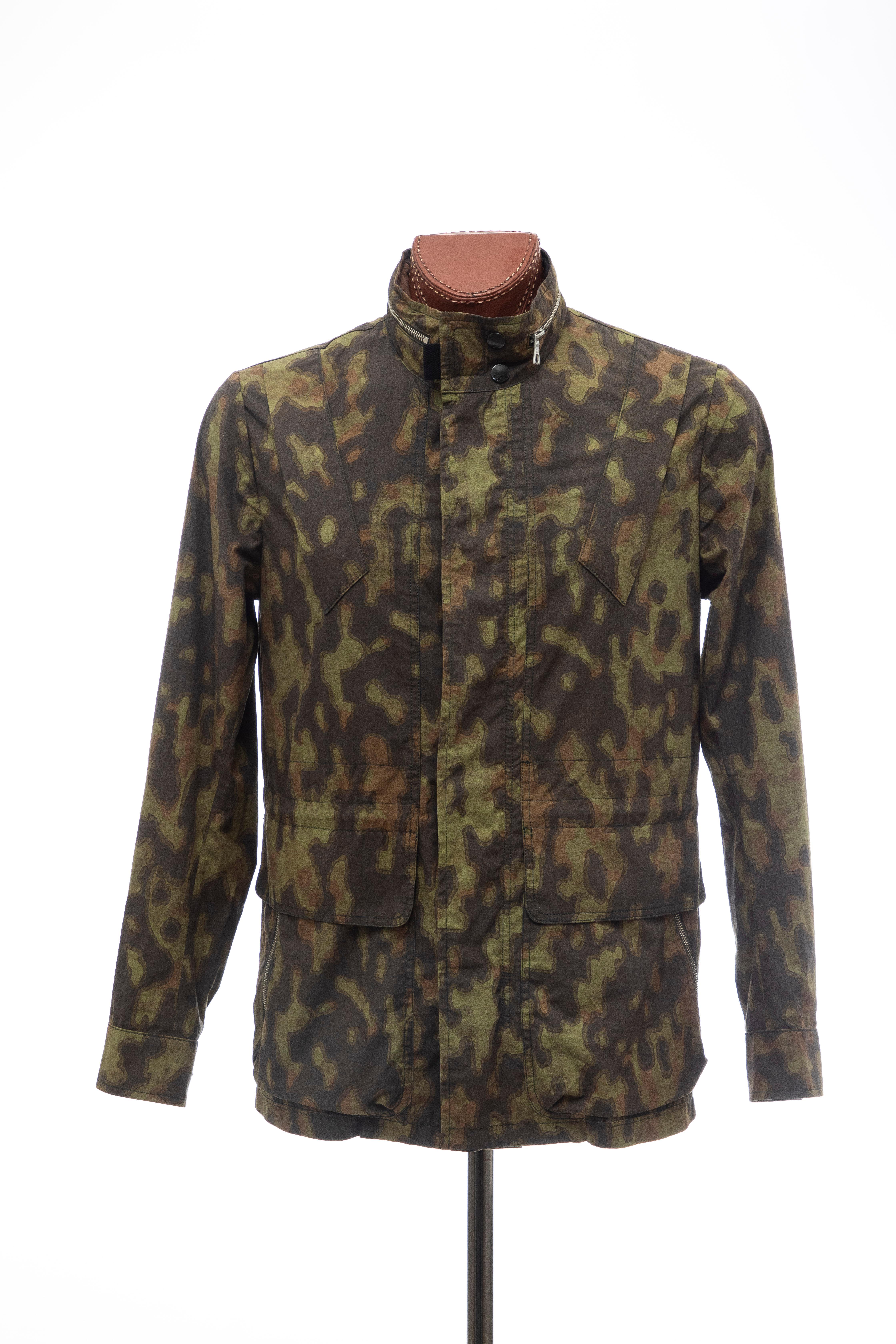 Dries Van Noten, Spring 2013 men's cotton zip front camouflage jacket, four zip front pockets, velcro and snap neck closure with zip concealed camouflage nylon hood.

EU, 50

Chest: 43, Waist: 43, Length: 30, Shoulder: 18.5, Sleeve: 26