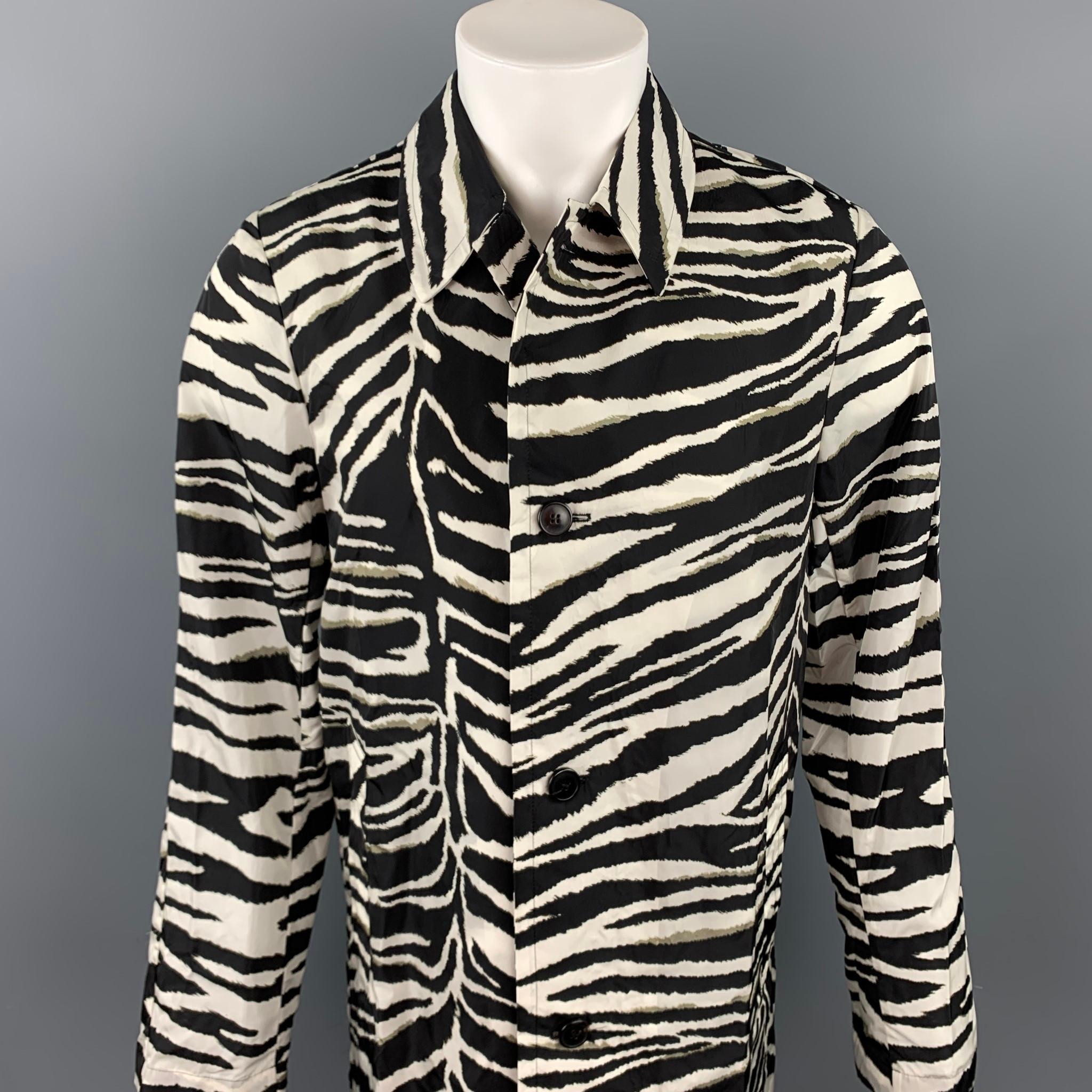 DRIES VAN NOTEN raincoat comes in a black & white zebra print polyamide featuring a spread collar, slit pockets, and a buttoned closure.

Brand New. 
Marked: 44
Original Retail Price: $1,275.00

Measurements:

Shoulder: 17 in.
Chest: 38 in.
Sleeve: