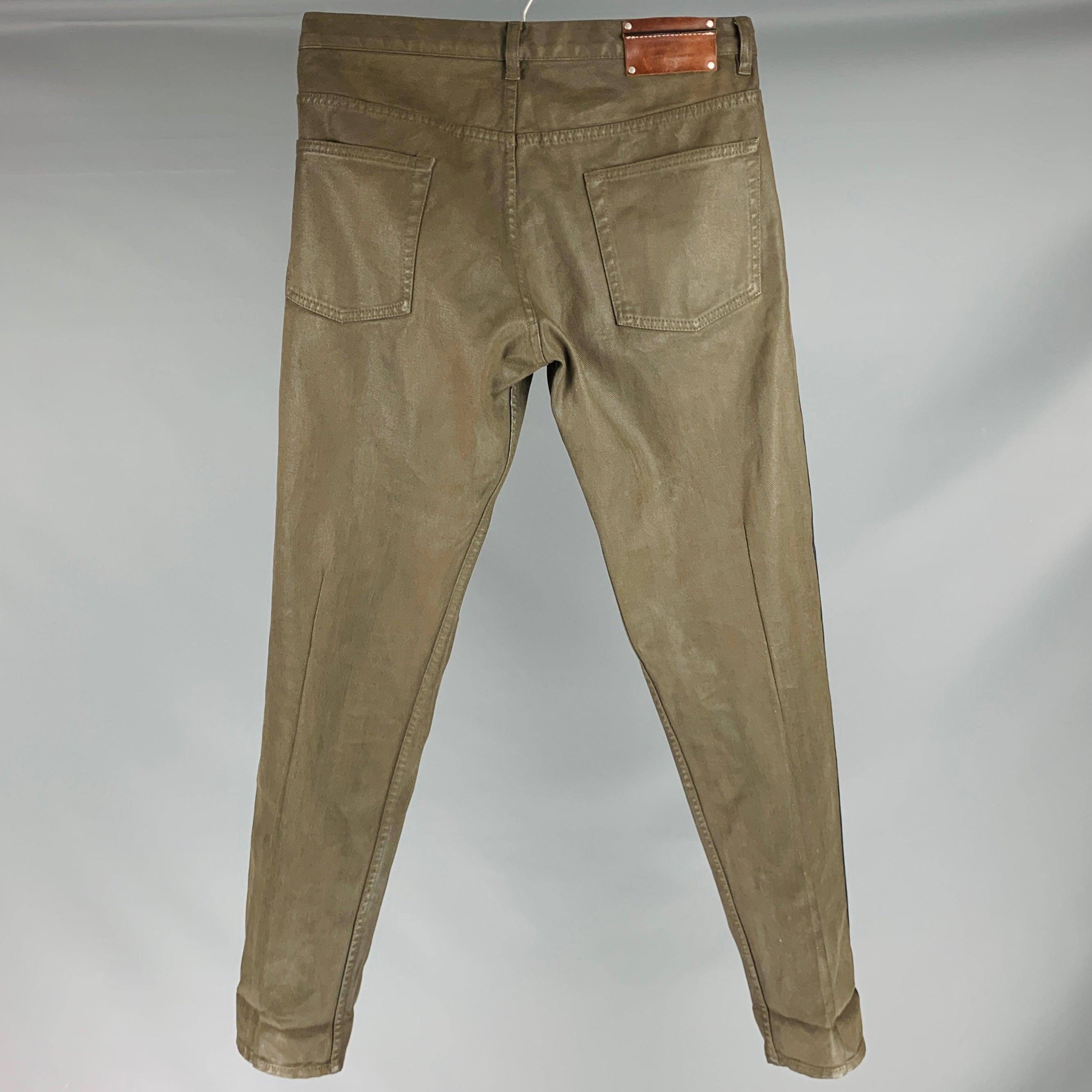 DRIES VAN NOTEN jeans
in an olive green coated cotton fabric featuring a cocoon style, black vertical stripe detail, and button fly closure.Excellent Pre-Owned Condition. 

Marked:   33 

Measurements: 
  Waist: 33 inches Rise: 9 inches Inseam: 32