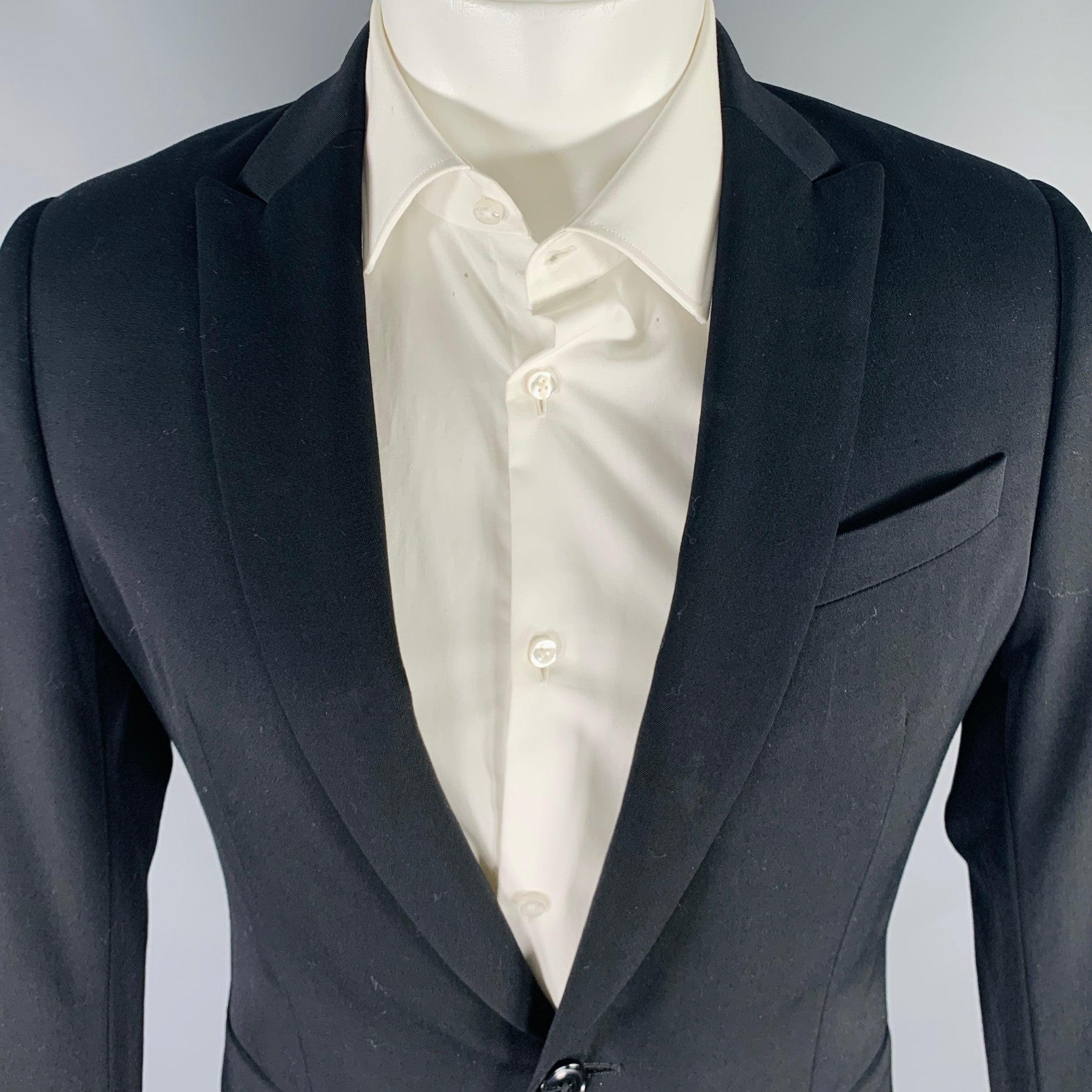 Manteau de sport Coates VAN NOTEN
en laine noire, avec un revers en pointe, une double fente au dos et une fermeture à bouton unique.Très bon état d'occasion. Marques sous les bras. 

Marqué :   48 

Mesures : 
 
Épaule : 16 pouces  Poitrine : 38