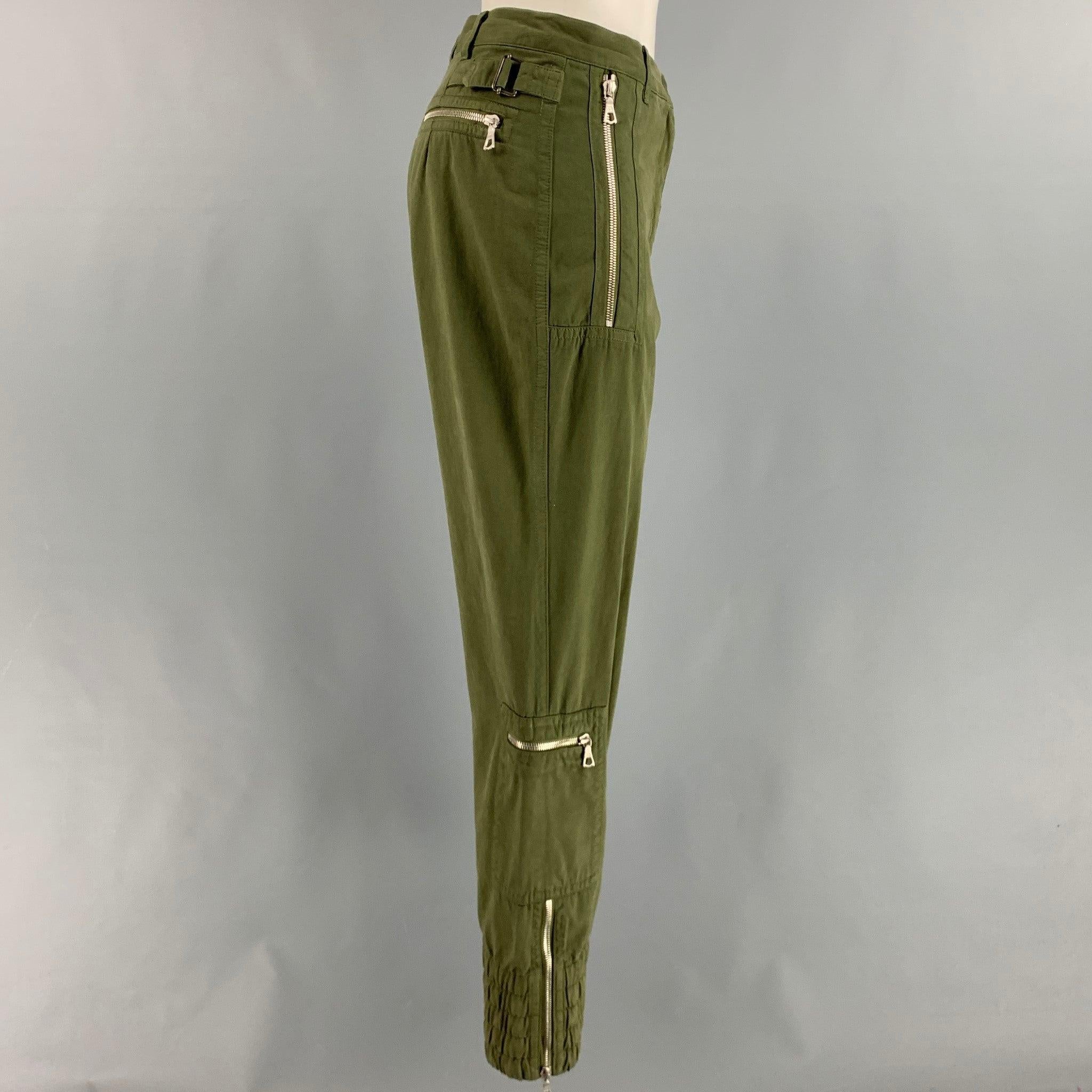 DRIES VAN NOTEN casual pants
in an olive green cotton fabric featuring zipper pockets, adjustable side tabs, elastic cuffs, and a zip fly closure. Made in Romania.New With Tags. 

Marked:   36 

Measurements: 
  Waist: 28 inches Rise: 8.5 inches