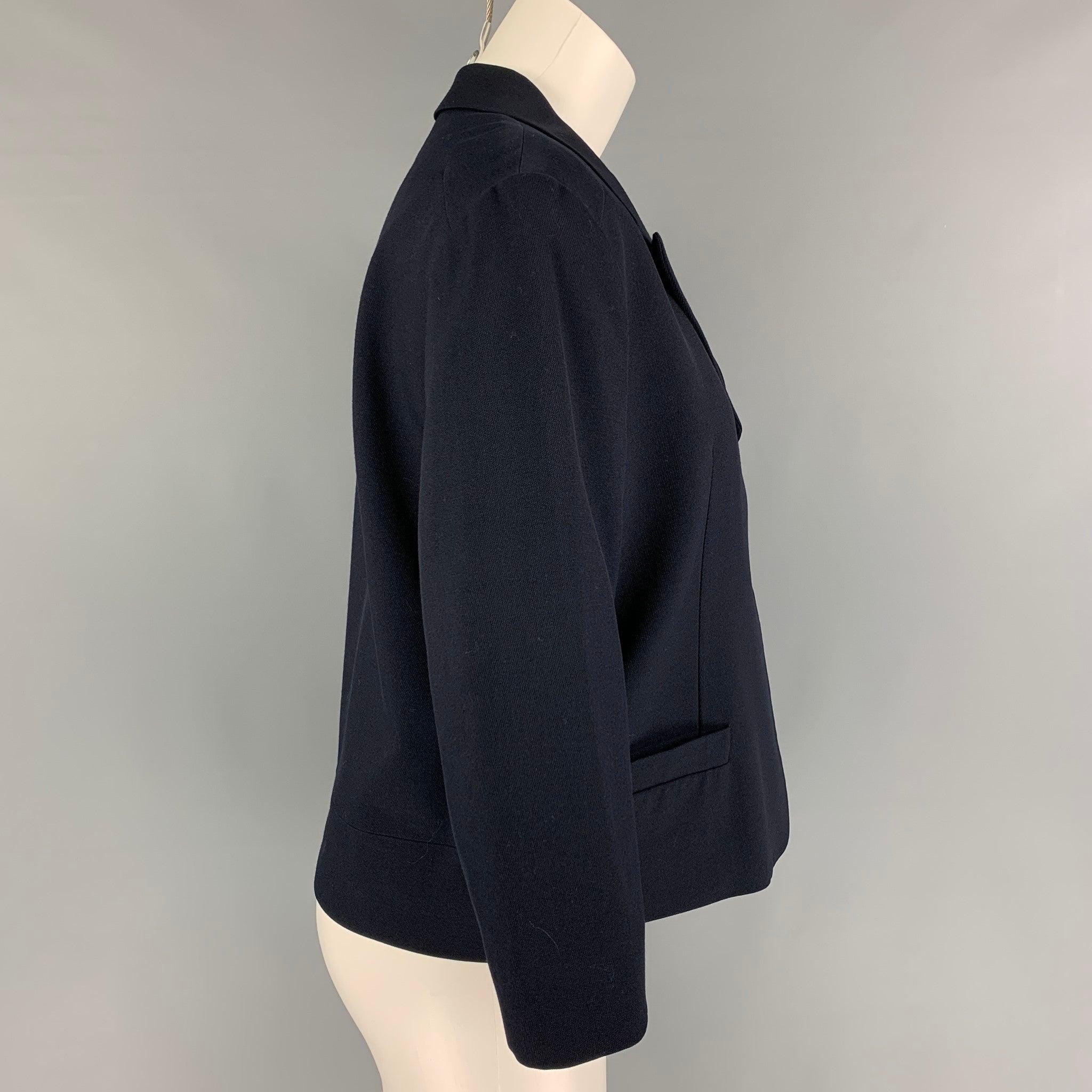 DRIES VAN NOTEN jacket comes in a navy wool blend featuring a cropped style, peak lapel, front pockets, and a snap button closure.
Very Good
Pre-Owned Condition. 

Marked:   40 

Measurements: 
 
Shoulder: 17.5 inches  Bust: 40 inches  Sleeve: 18.5