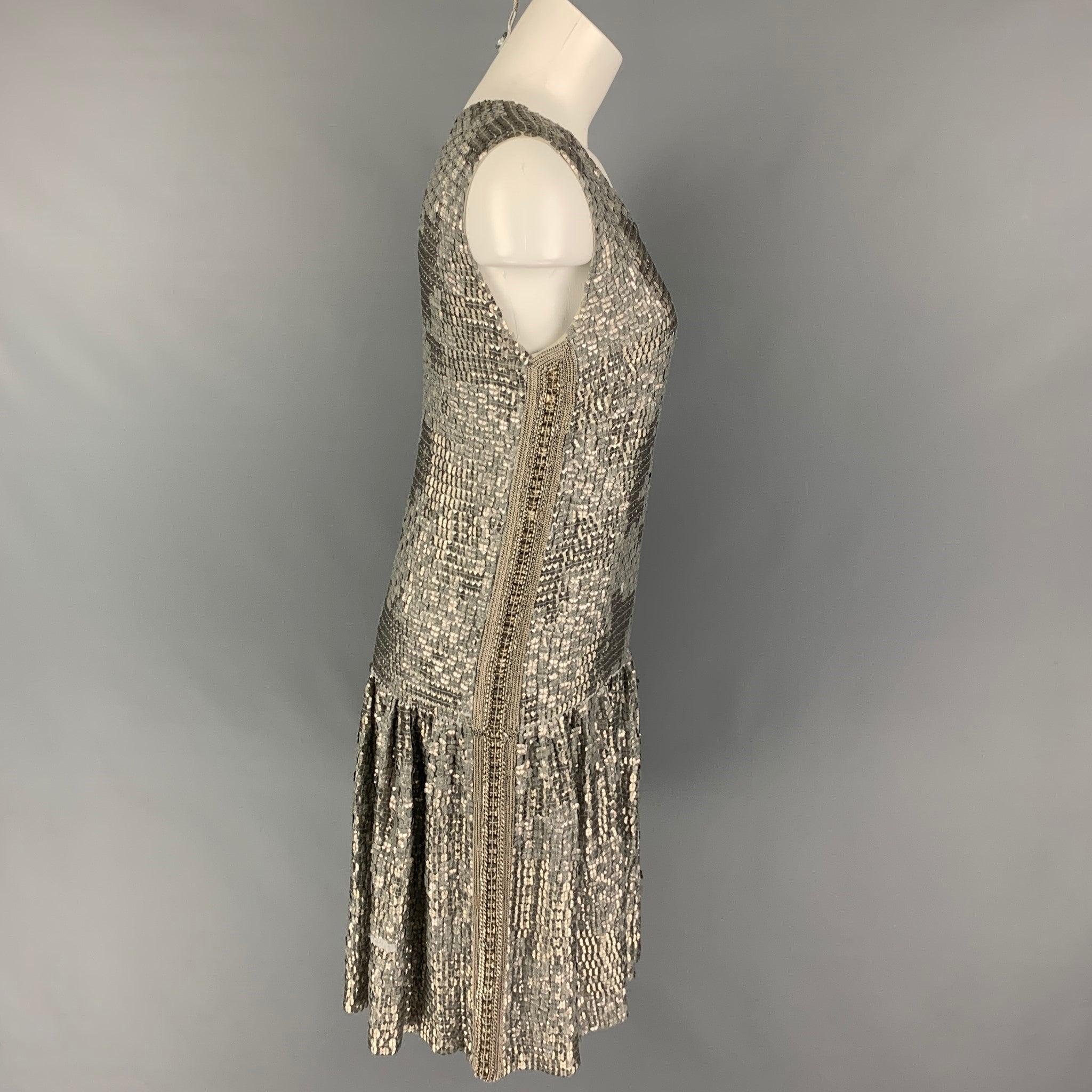 DRIES VAN NOTEN dress comes in a silver sequined silk featuring a shift style, sleeveless, chain link trim, and a scoop neckline.
Very Good
Pre-Owned Condition. 

Marked:  40 

Measurements: 
 
Shoulder: 14.5 inches Bust: 36 inches Waist: 37 inches
