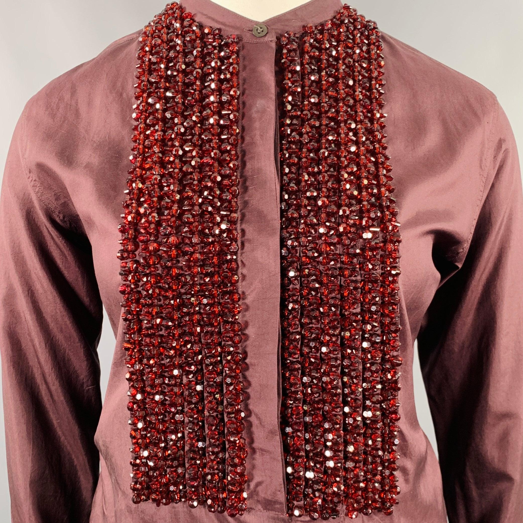 DRIES VAN NOTEN shirt
in a brown silk featuring a collarless style, beaded front design, French cuffs, and hidden button closure. Very Good Pre-Owned Condition. Minor signs of wear. 

Marked:   IT 42 

Measurements: 
 
Shoulder: 16.5 inches Bust: 42