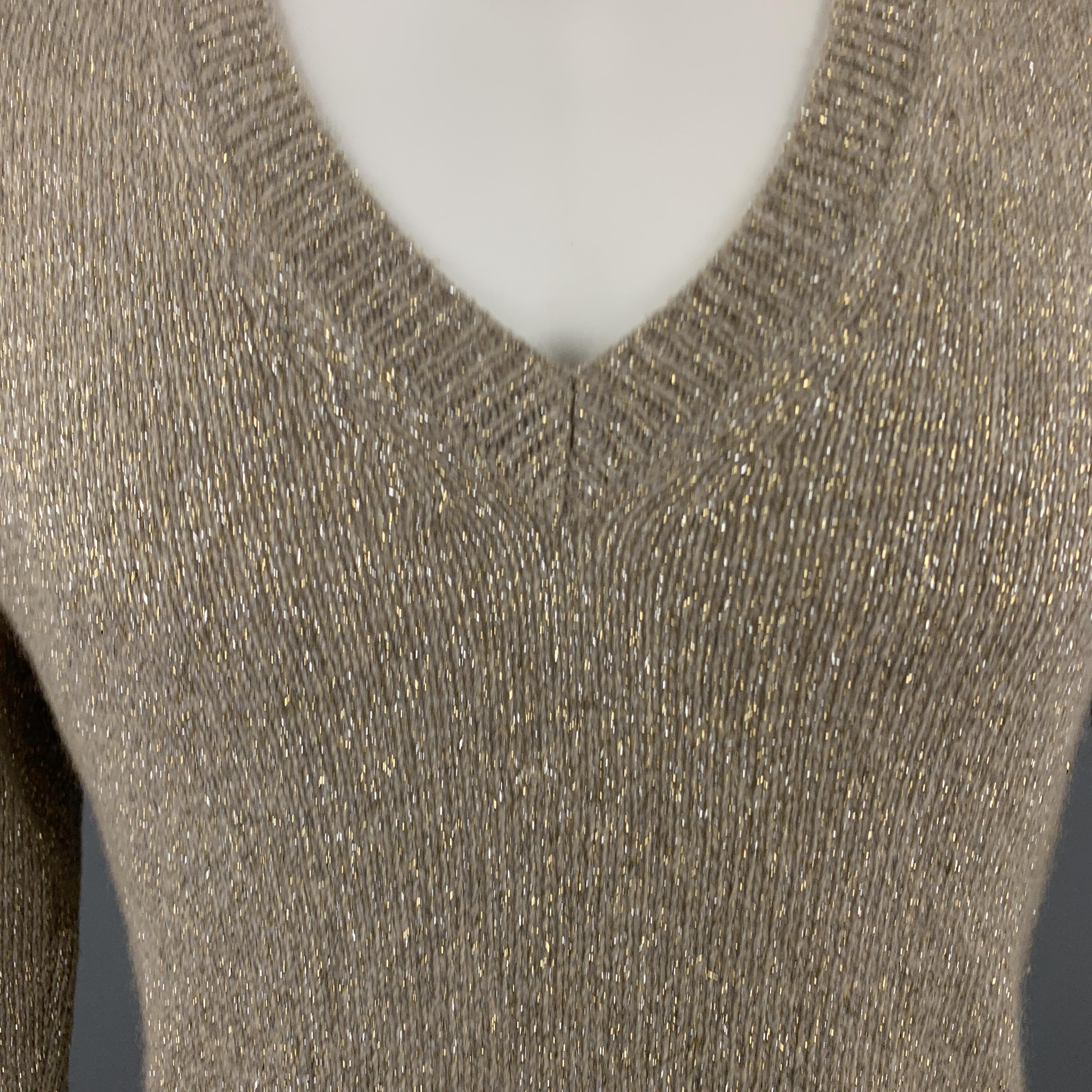 DRIES VAN NOTEN sweater comes in gold sparkle knit with a V neck and ribbed waistband. Made in Belgium. 

Very Good Pre-Owned Condition.
Marked: Medium

Measurements:

Shoulder: 17 in.
Chest: 40 in.
Sleeve: 28 in.
Length: 27 in.