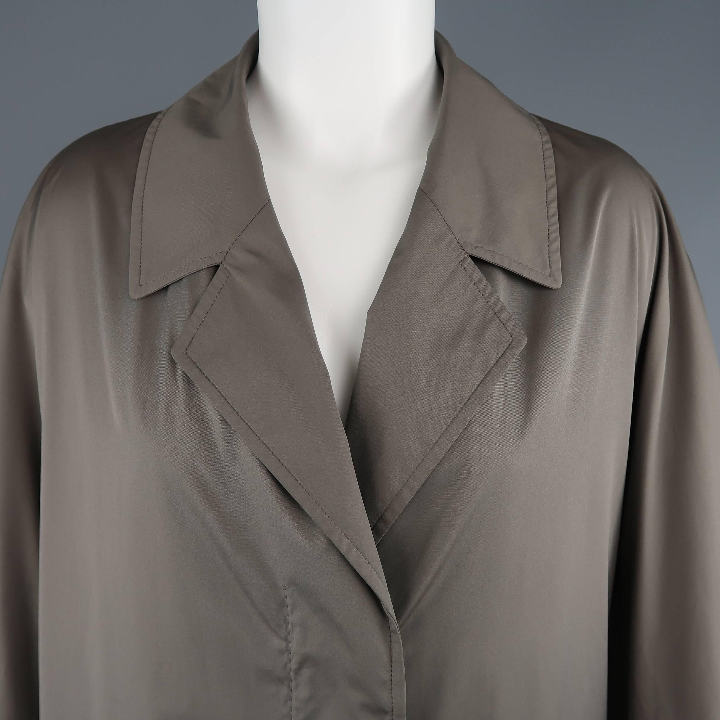 DRIES VAN NOTEN coat comes in muted olive grey windbreaker fabric with a notch lapel, hidden placket button up front, thick sleeves, and A line silhouette. Made in Belgium.
 
Excellent Pre-Owned Condition.
Marked: Medium
 
Measurements:
 
Shoulder: