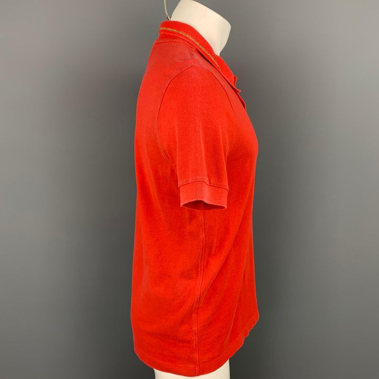 DRIES VAN NOTEN polo comes in a orange cotton with a gold trim featuring a spread collar and a buttoned closure. Made in Portugal.

Good Pre-Owned Condition.
Marked: M

Measurements:

Shoulder: 17 in.
Chest: 40 in.
Sleeve: 10 in.
Length: 27.5 in. 