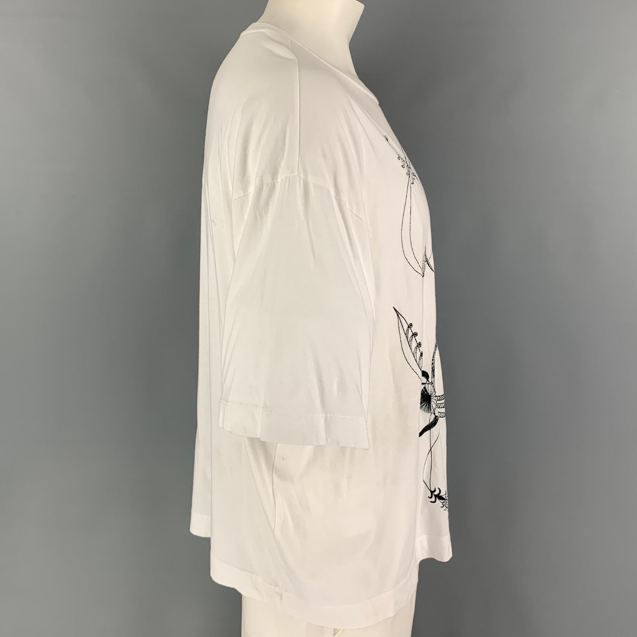 DRIES VAN NOTEN t-shirt comes in a white & black cotton featuring embroidered designs and a crew-neck. 

Good Pre-Owned Condition. Moderate discoloration throughout. As-is.
Marked: M

Measurements:

Shoulder: 26 in.
Chest: 48 in.
Sleeve: 10.5