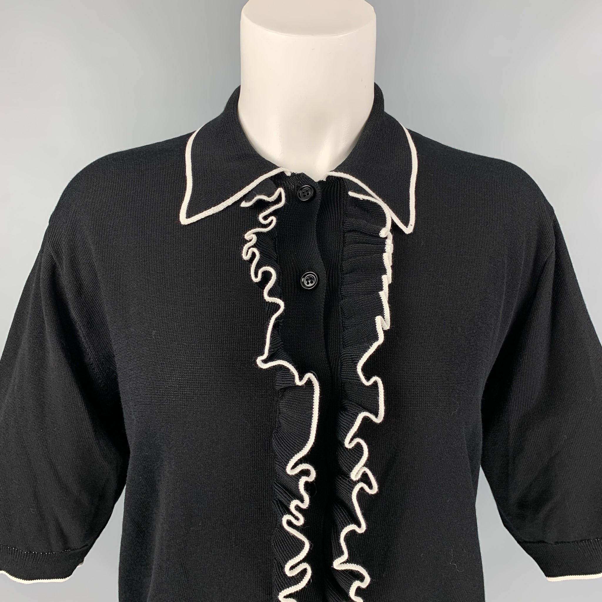DRIES VAN NOTEN polo shirt comes in a black & white viscose / cotton featuring a ruffled trim, pointed collar, and a buttoned closure. 

Excellent Pre-Owned Condition.
Marked: S

Measurements:

Shoulder: 17 in.
Bust: 36 in.
Sleeve: 12 in.
Length: