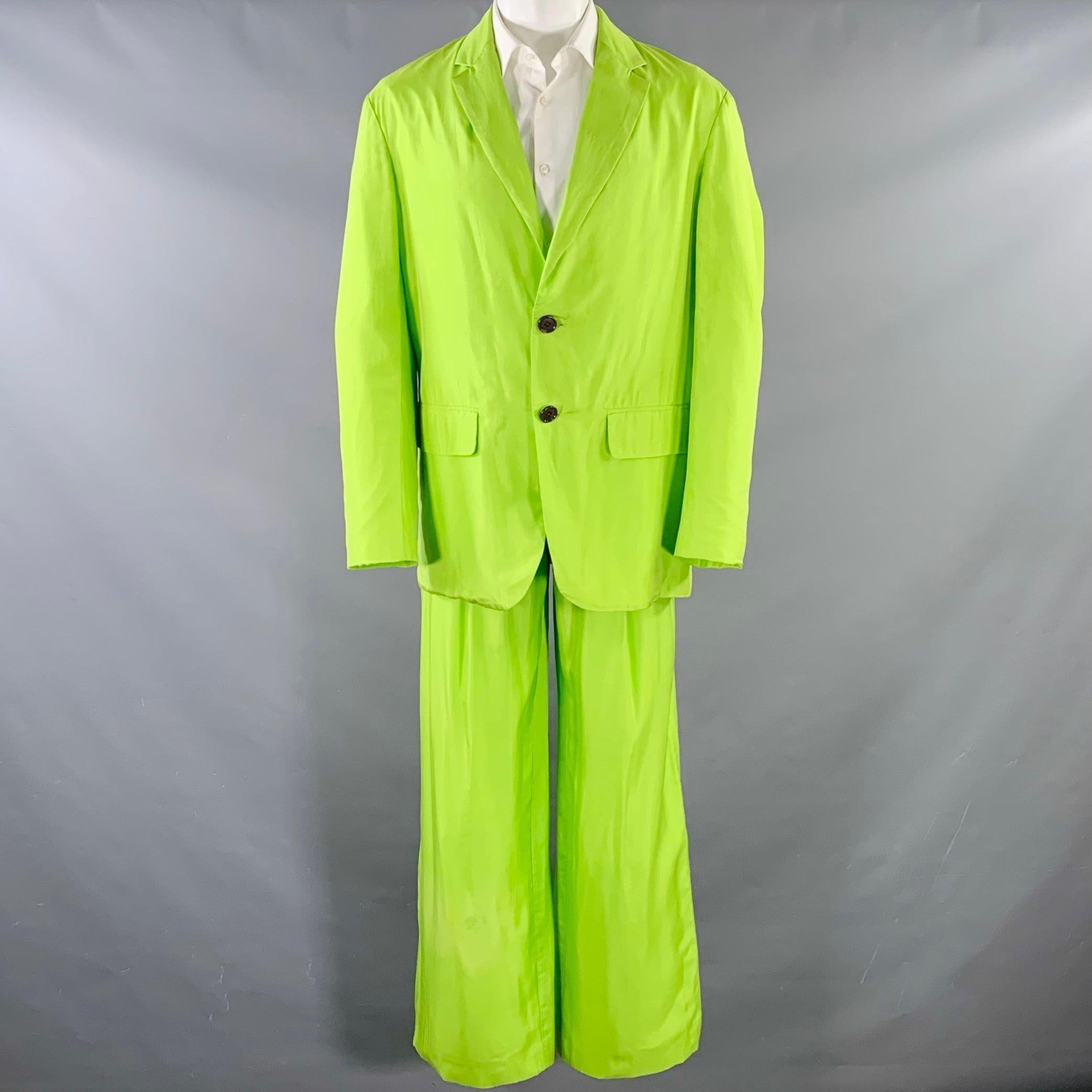 DRIES VAN NOTEN suit
in a neon green silk cotton blend with full liner and includes a single breasted, double button sport coat with a notch lapel and matching pleated trousers.Very Good Pre-Owned Condition. Discoloration on shin of right leg, which