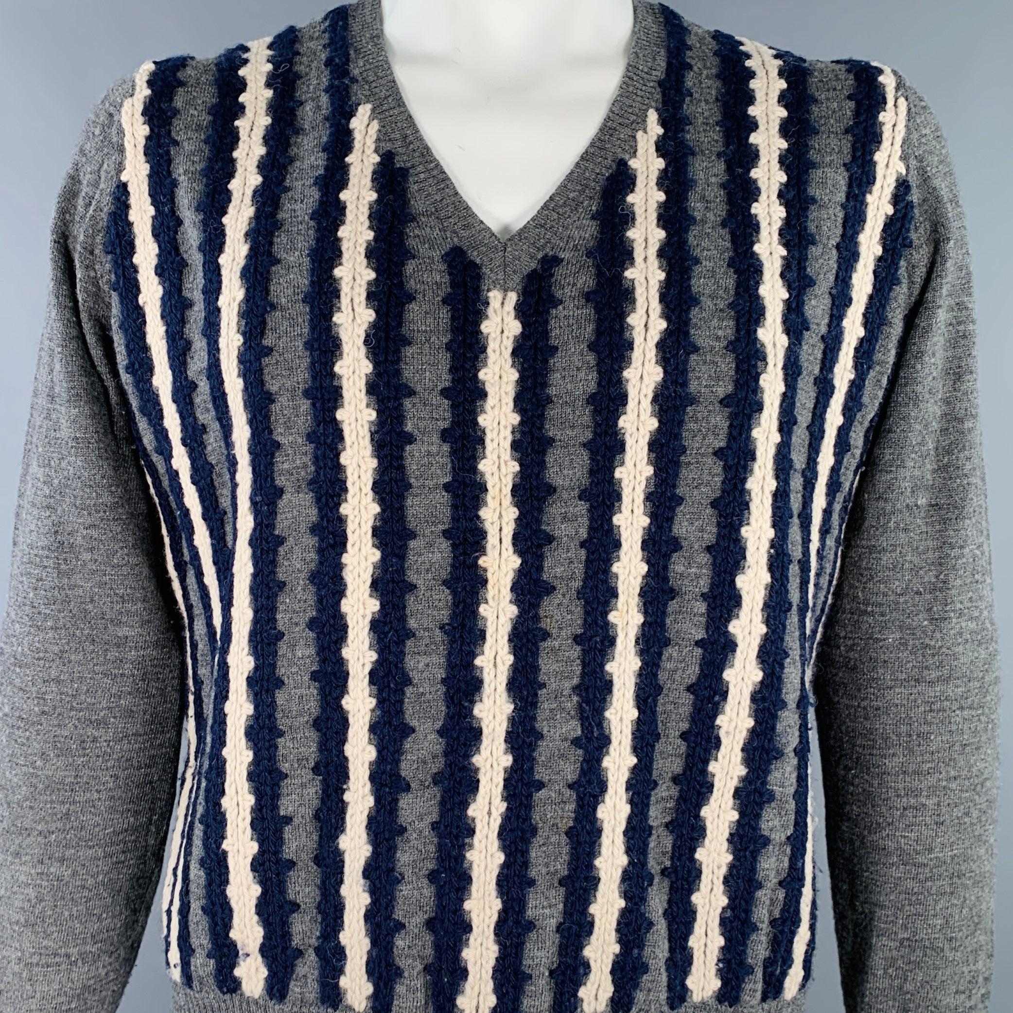 DRIES VAN NOTEN pullover
in a grey wool knit featuring a navy and cream braided stripe pattern, long sleeves, and V-neck. Made in Belgium.Very Good Pre-Owned Condition. Minor pilling, minor mark on front that is hard-to-see. 

Marked:   XL