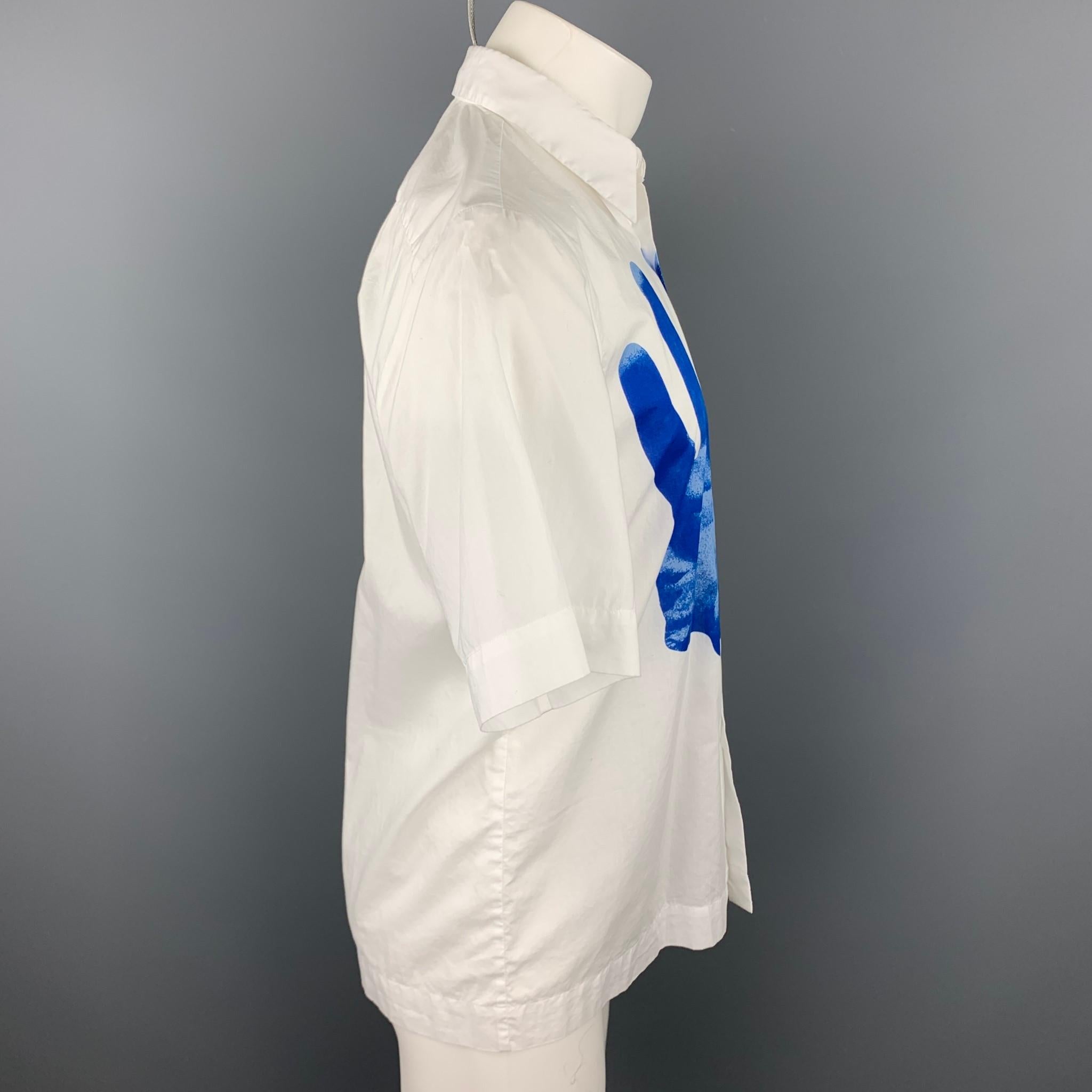 Das kurzärmelige Hemd von DRIES VAN NOTEN S/S 19 besteht aus weißer & blauer Baumwolle mit einem Handdruck von Verner Panton. Es lässt sich hochknöpfen und hat einen breiten Kragen. 

Ausgezeichneter gebrauchter Zustand. 
Markiert: 46

Messungen: