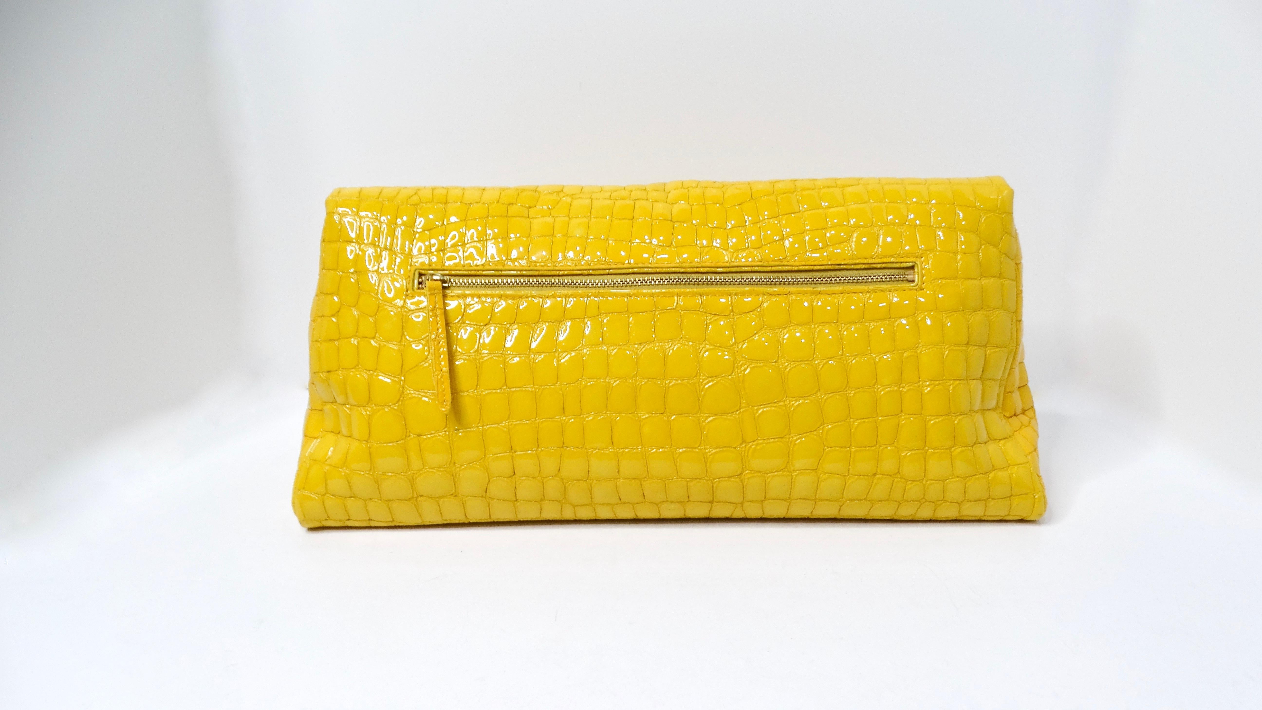The Dries Van Noten Yellow Glossed Faux Croc Large Clutch Bag is a striking accessory that effortlessly combines functionality with high fashion. Crafted in a mustard-toned faux crocodile leather, this large envelope-shaped clutch offers ample space